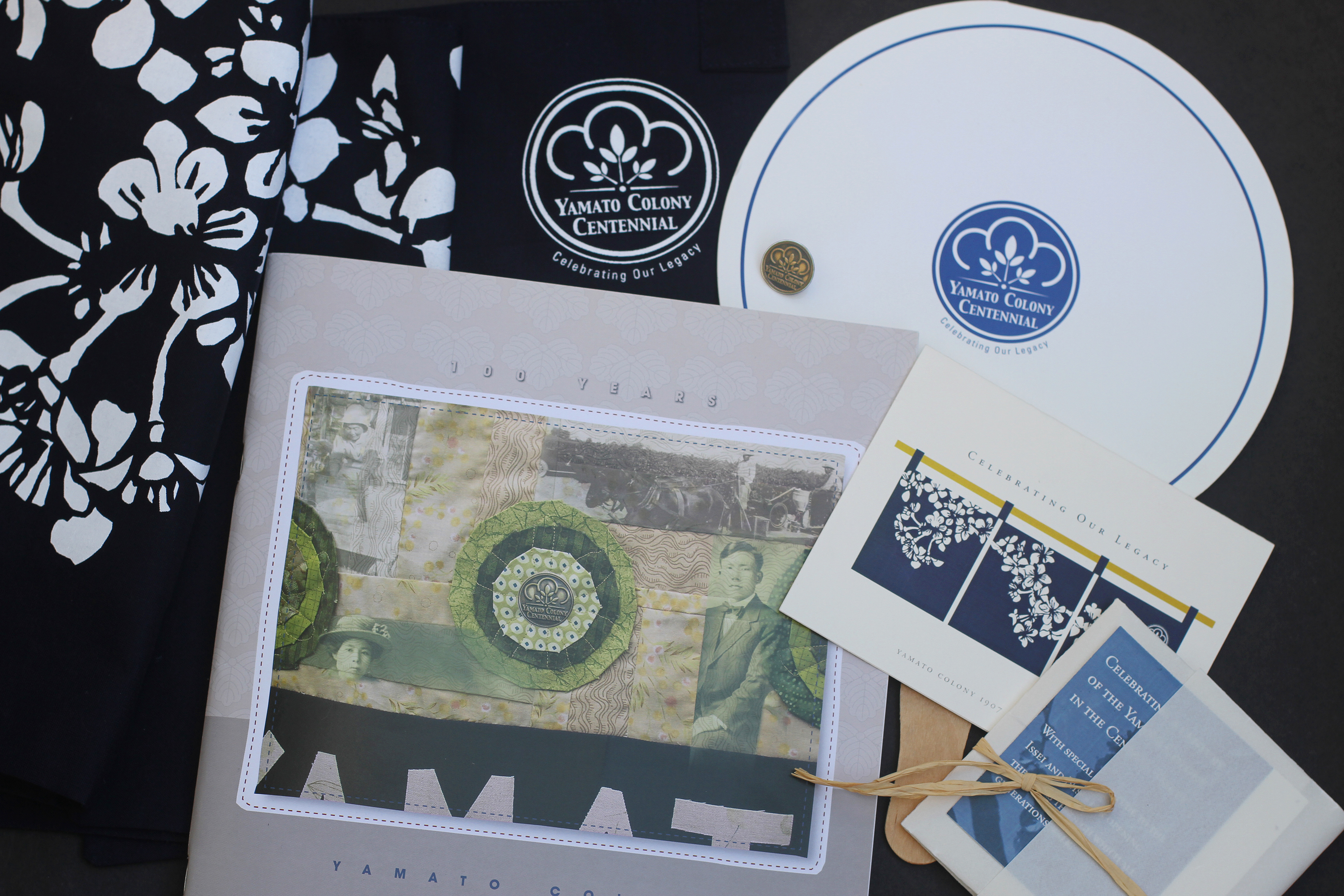 Yamato Colony Centennial Celebration: Livingston CA. Logo and identity system, program, logo pin, fan, card, noren, 32 page Memory Book. Designed by Maryann Ohki.