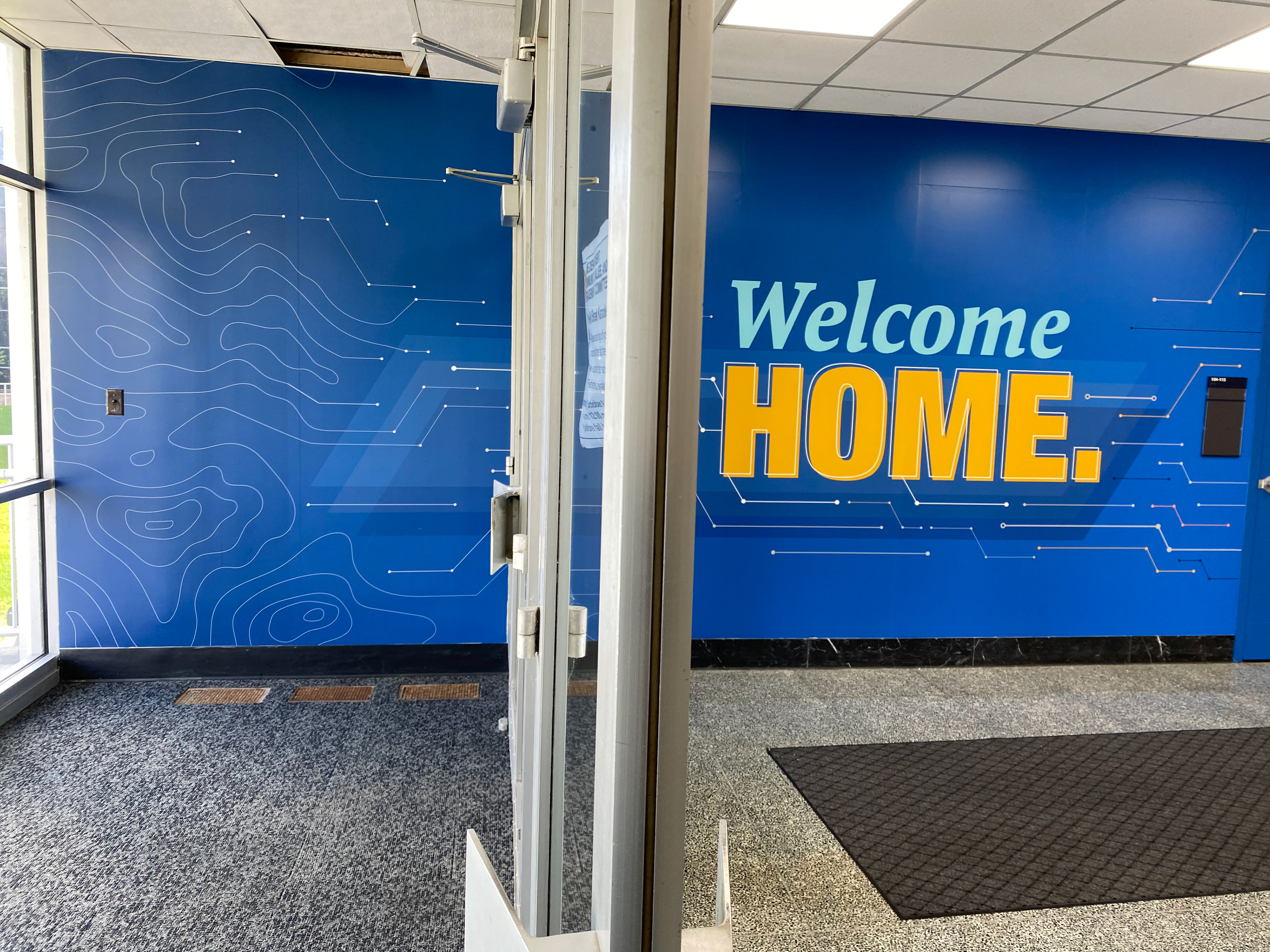 Photo of the first section of the installed wall from the glass entrance doors.
