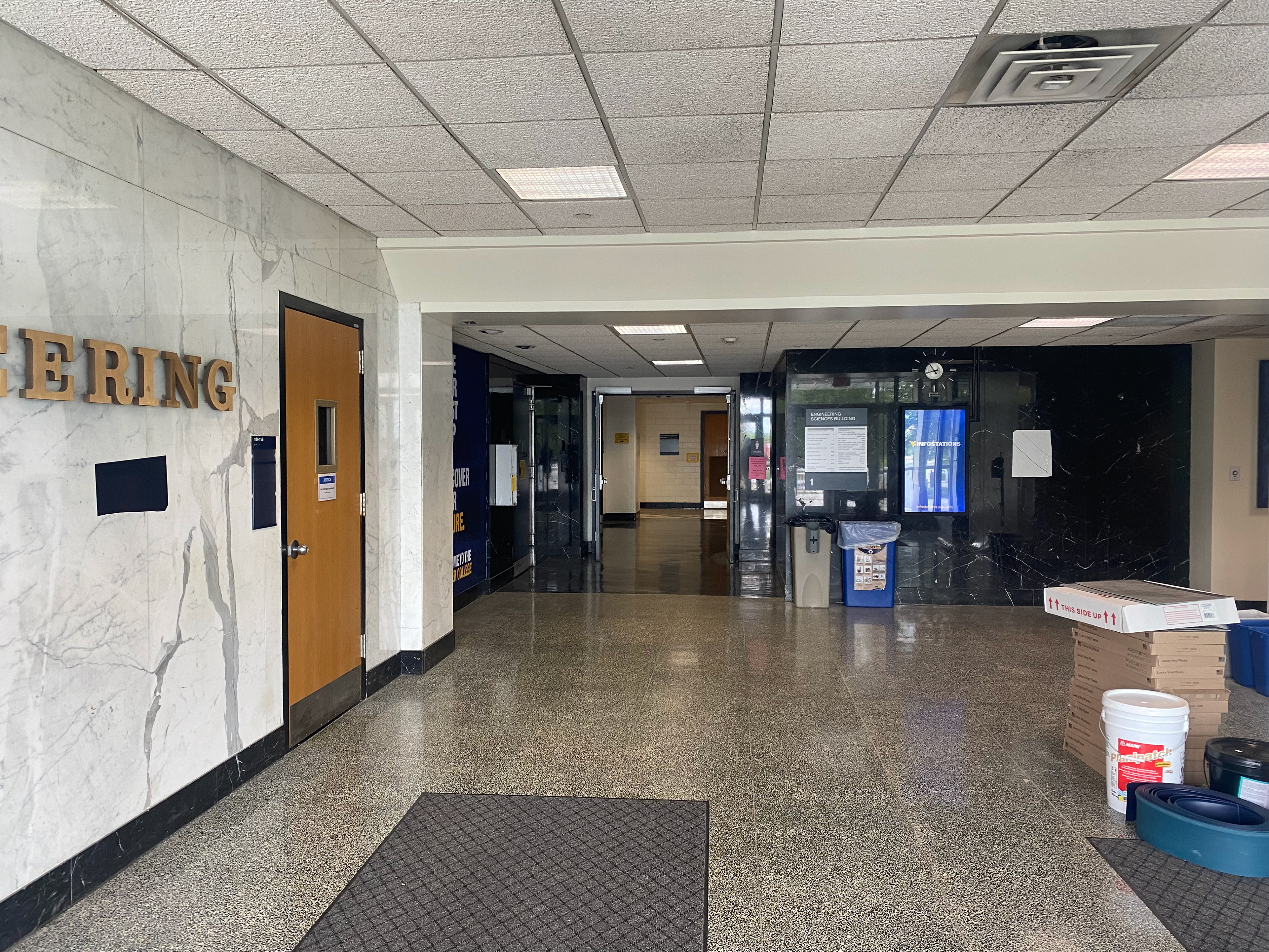 The main floor of Engineering Sciences Building from doors, with a single white marble wall to the left and several black marble walls stretching into the distance