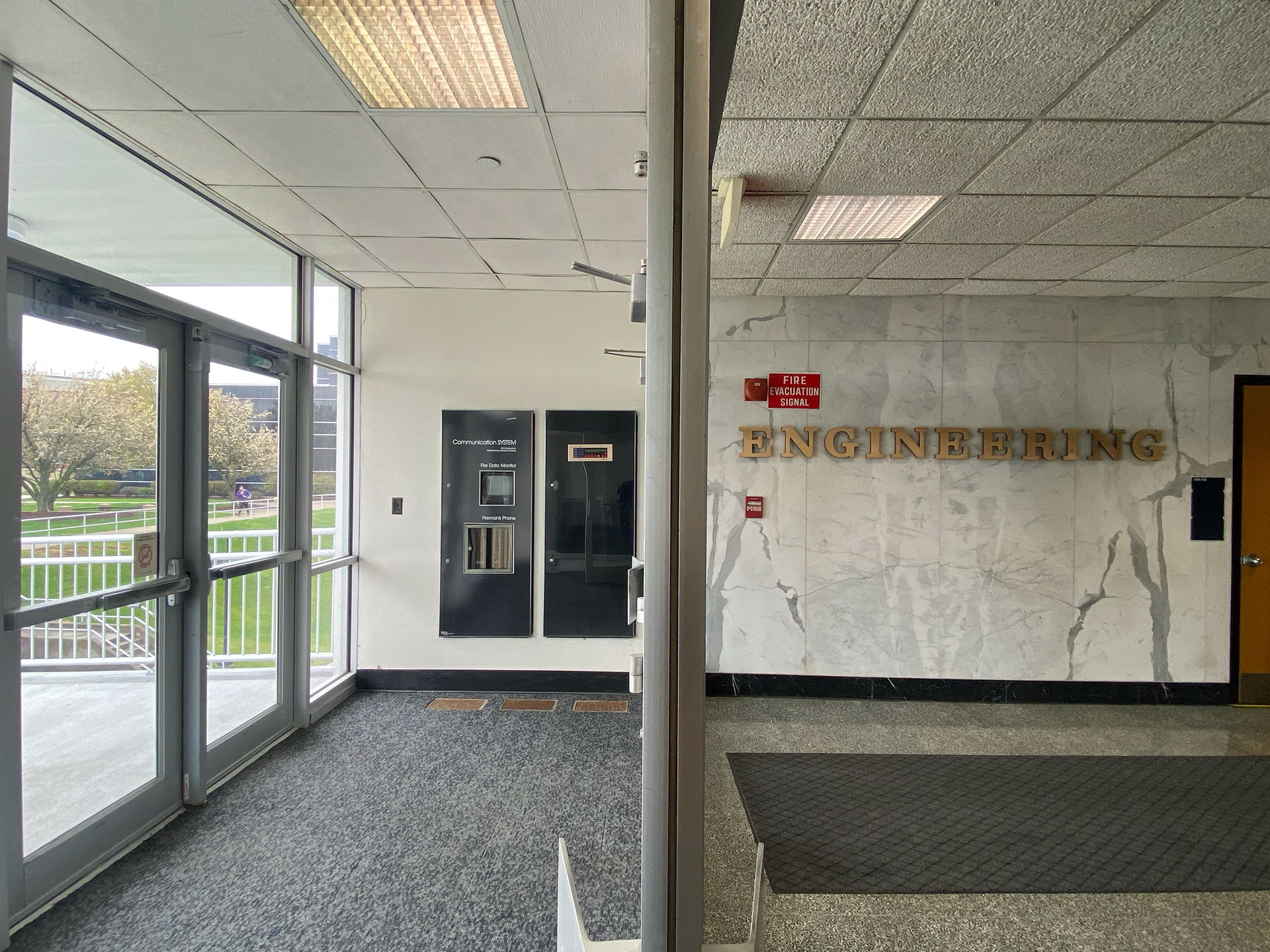The view from the atrium, leading the path outside into the Engineering Sciences Building. Multiple sets of double glass doors separate the entrance from the main floor