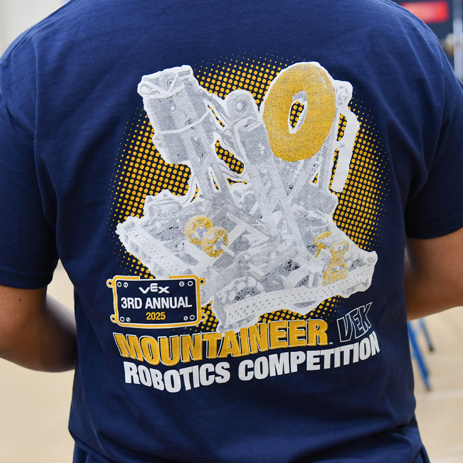 2025 3rd Annual VEX Mountaineer Robotics Competition t-shirt; the WVU team's robot is silhouetted against a halftone pattern on the shirt.