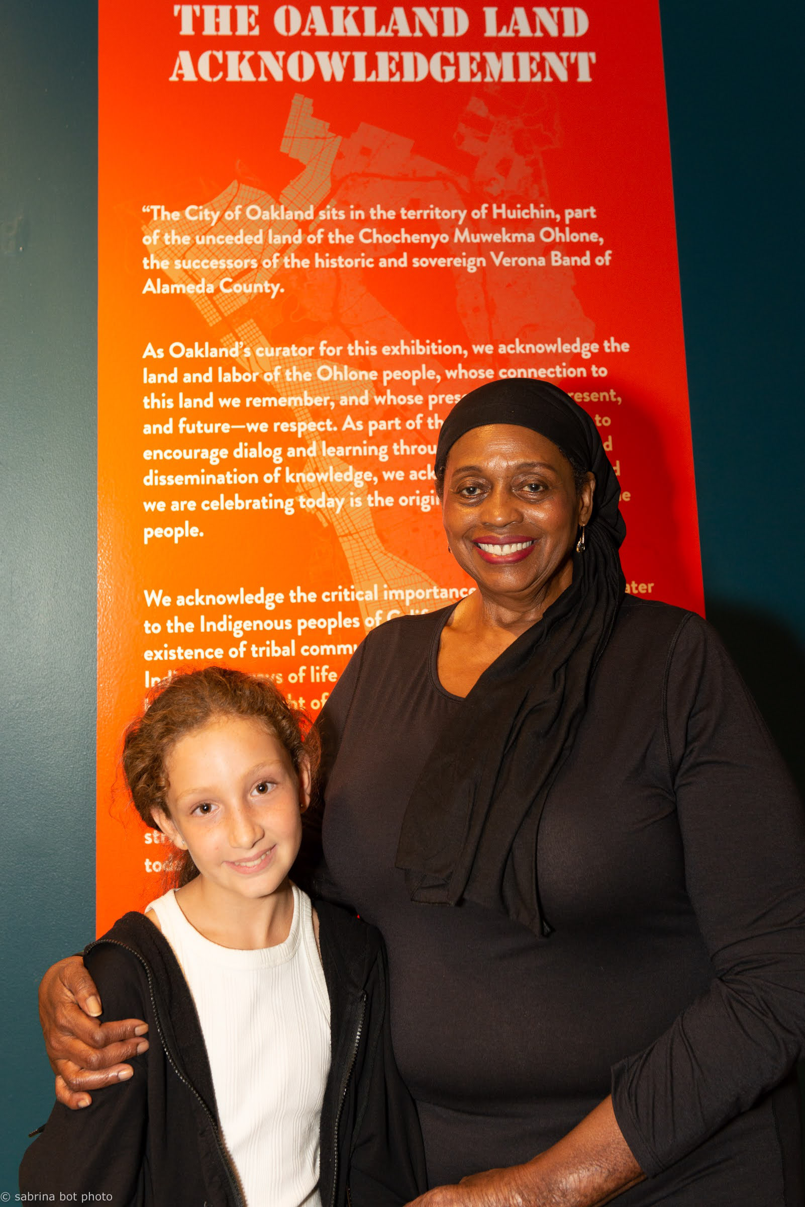 Inauguration de l’exposition à SPUR, San Francisco, août 2022. La poète ayodele nzinga devant la déclaration de reconnaissance du territoire d’Oakland.