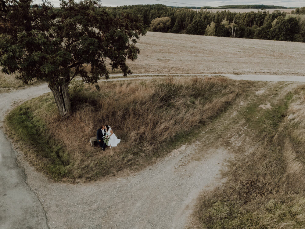 Portrétní fotografie novomanželů zachycená dronem na svatebním místě Statek Keseg nedaleko od Plzně.