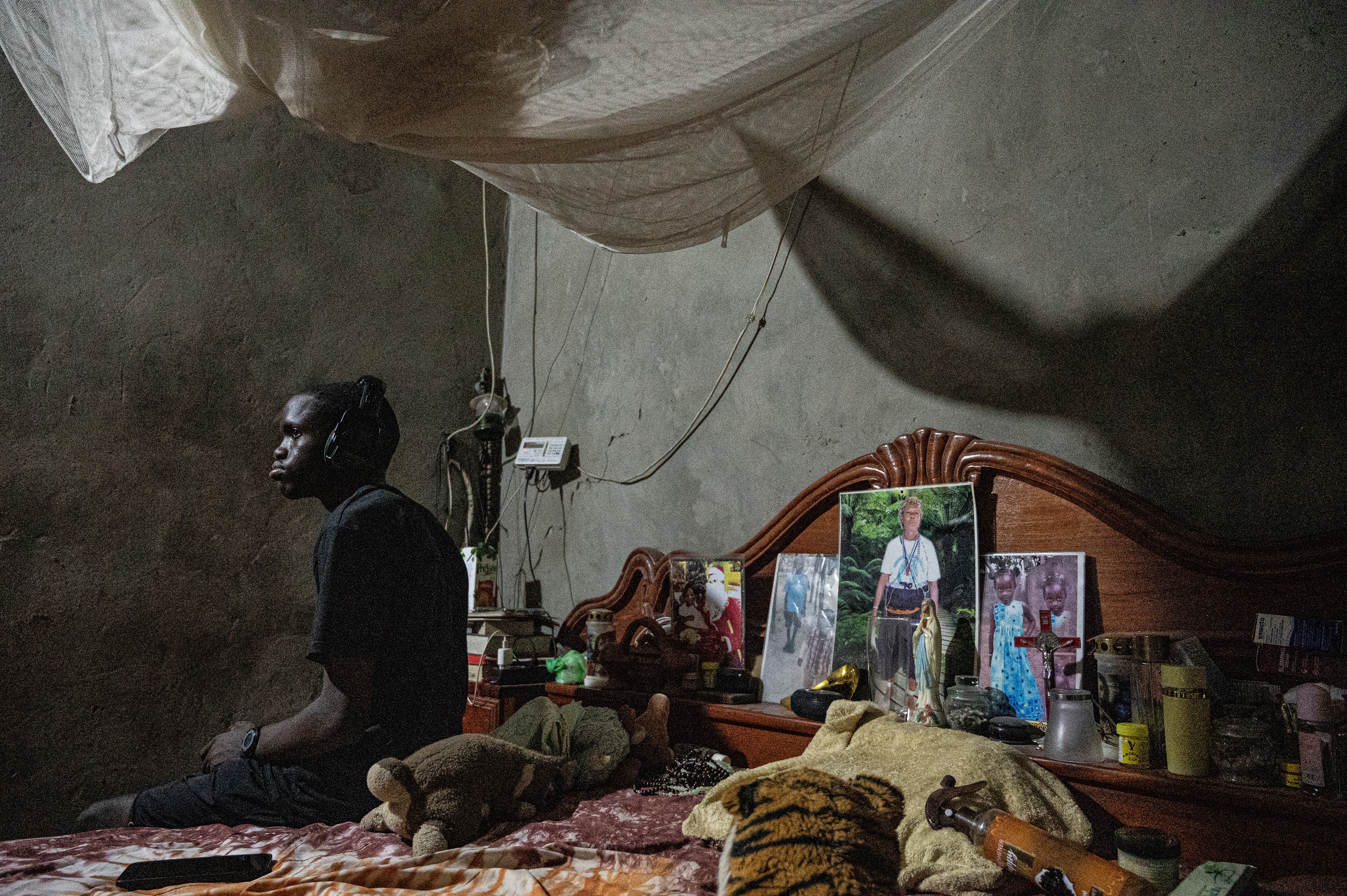 Stefano, a novice at the Boukout ceremony vigil, seating on the bed in Sengalene village, Casamance region, Senegal. August 22, 2026.