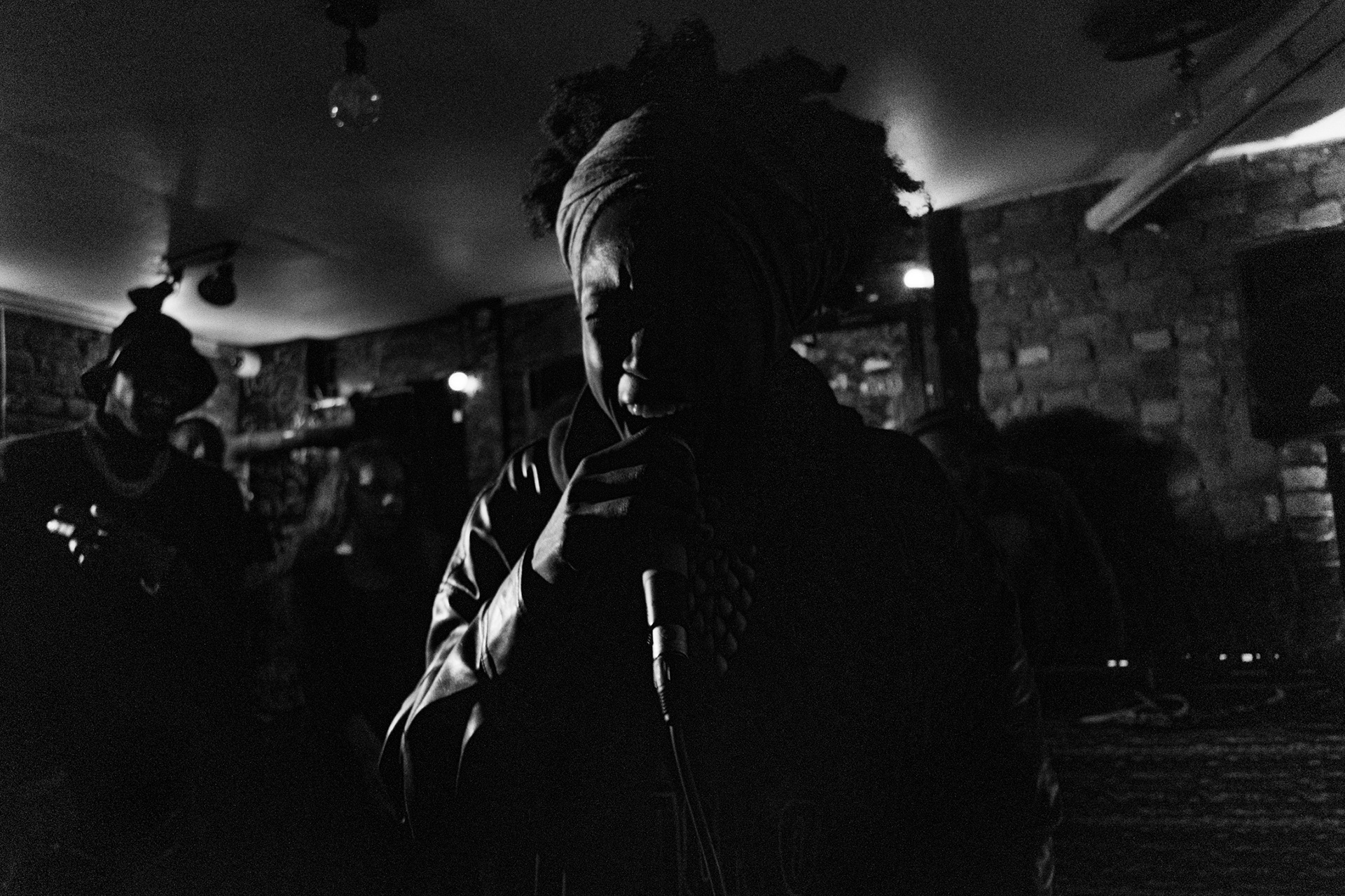 “Les Apaches” bar, Belleville, 20th arrondissement, Paris. November 28, 2025. RoseOyemi, a member of the BlackoutGeneration collective, performs her track “Guerrilla”  at the “Les Apaches” bar during the O2LA open mic night, organised by Le Dems, who is also a member of the collective. 