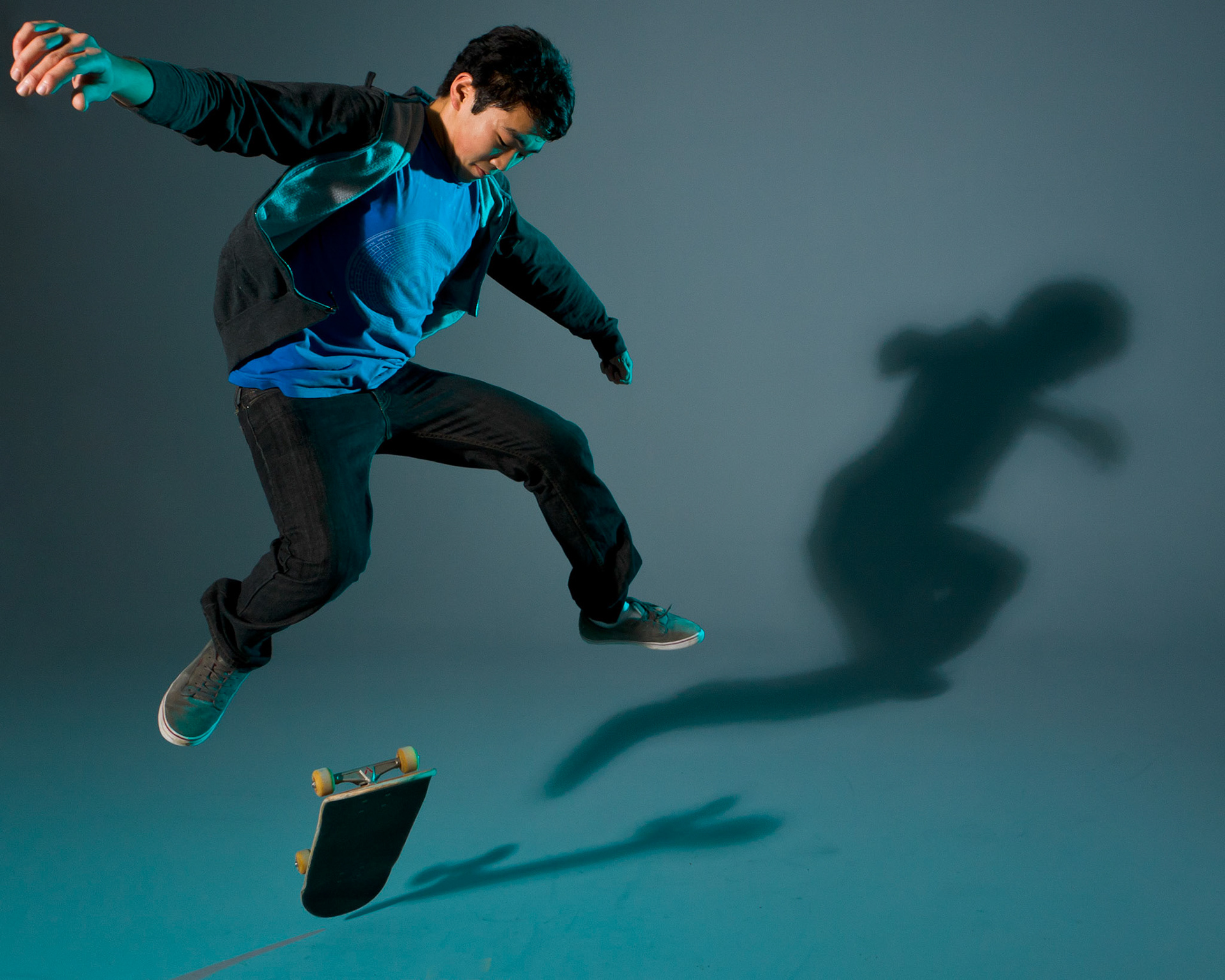 Studio cyclorama shot of a teen performing skateboarding tricks.
