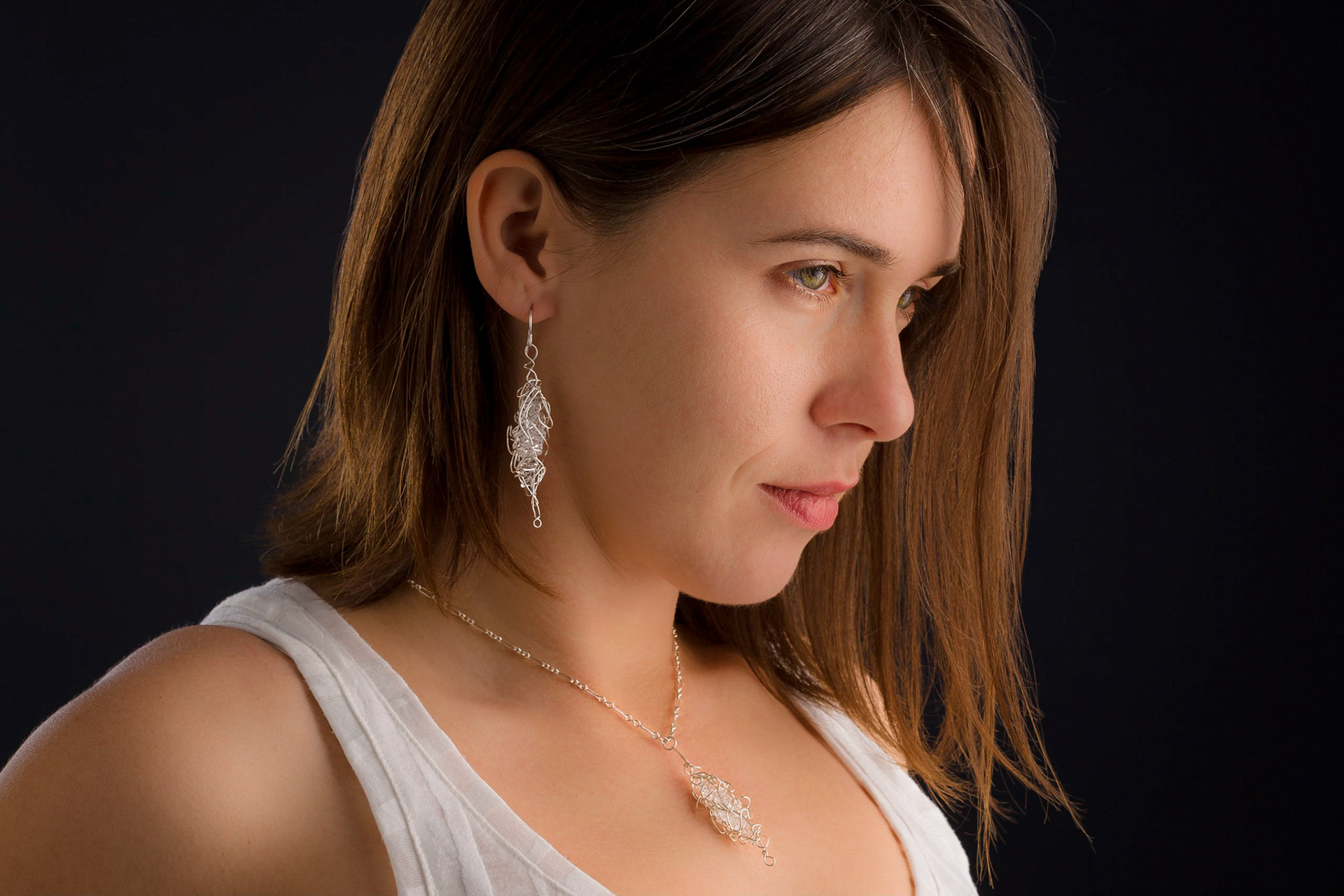 Model wearing examples of Drew Helge's micro sculpture jewelry for a series of ads for the artist.