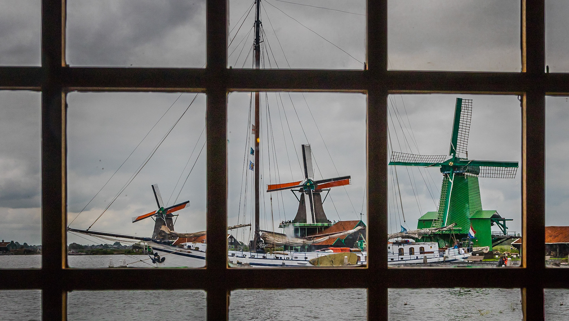 Three Zaanse Schans windmills framed in panes of a window in a 4th windmill.  Zaanse Schans (near Amsterdam), Netherlands (2018)