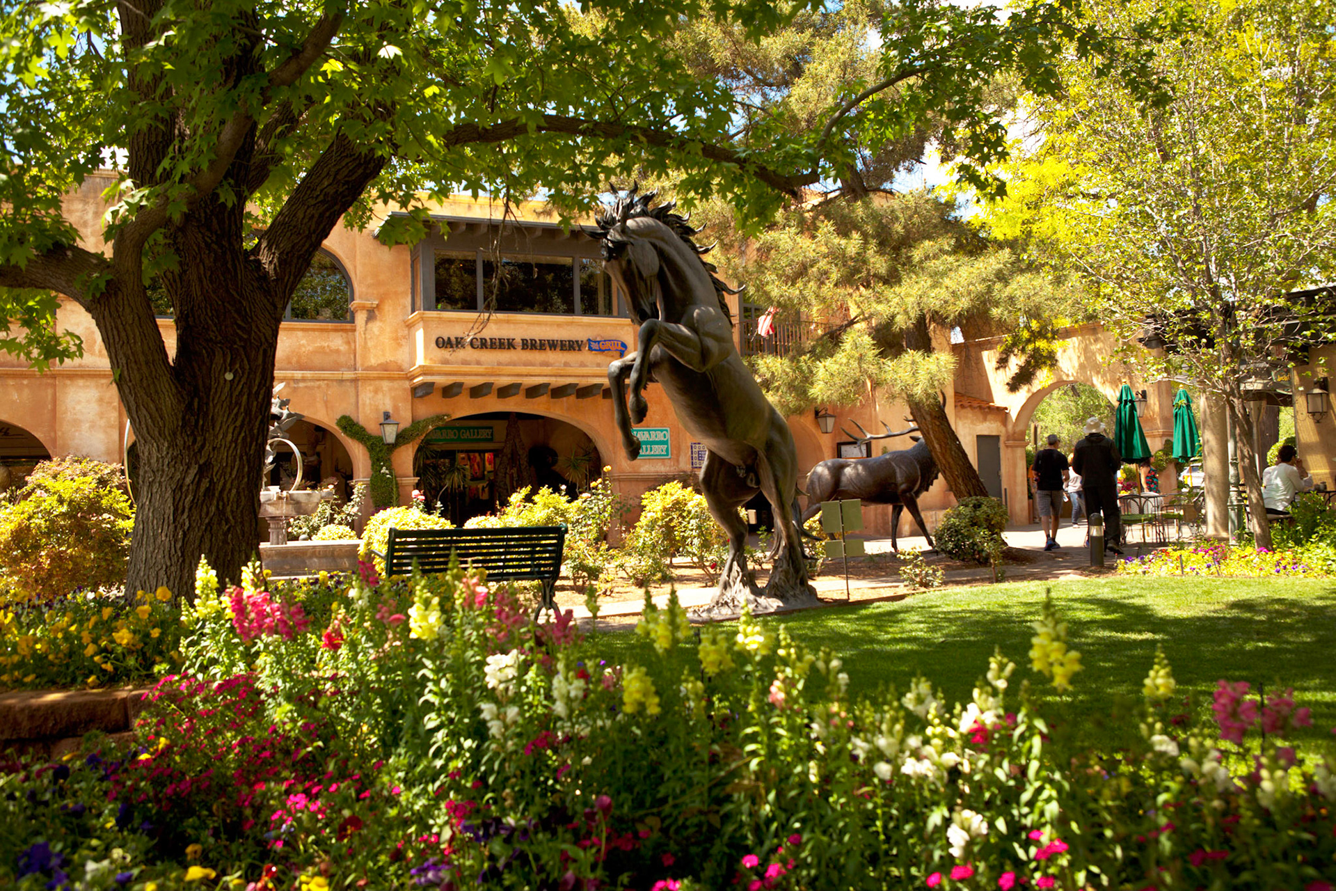 Mustang Pride by artist Chris Navarro. Statues, foliage and restaurants cover the grounds of Tlaquepaque.