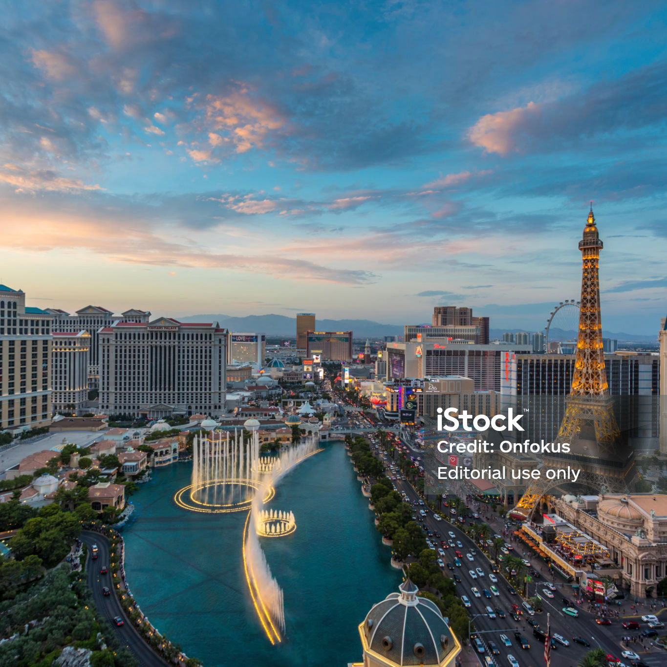 Sunset time high-angle view of the Las Vegas strip featuring the Eiffel tower replica and the fountains of Bellagio as well as the resort hotels Bellagio, Paris-Las Vegas, Ballys and Caesars Palace.