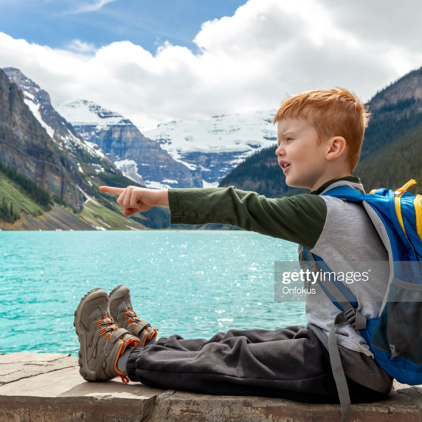 Young Cute Redhead Boy Looking at Lake Louise in Banff National Park, Canada