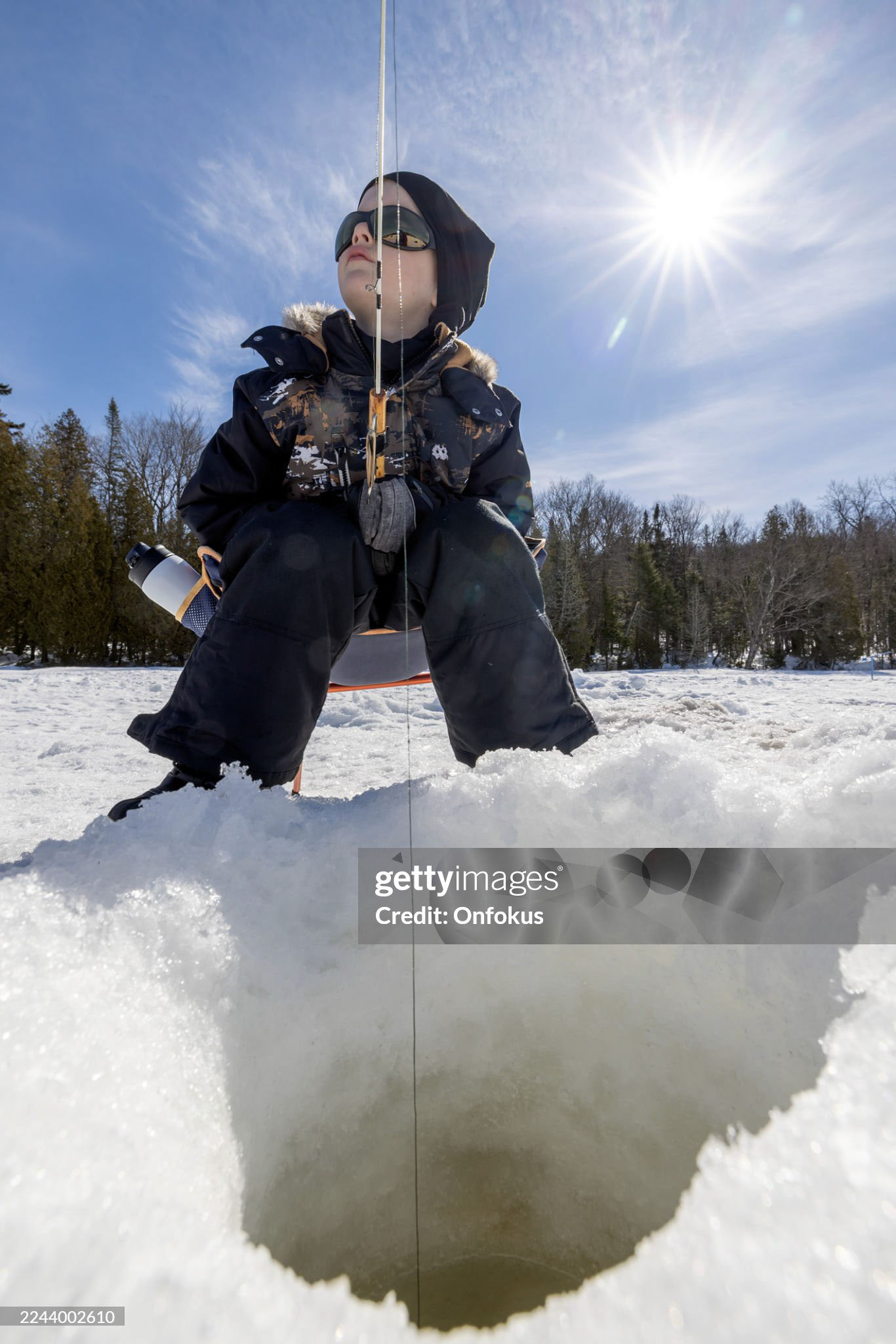 Young Boy Catching Fish While Ice Fishing in Winter, Quebec, Canada.