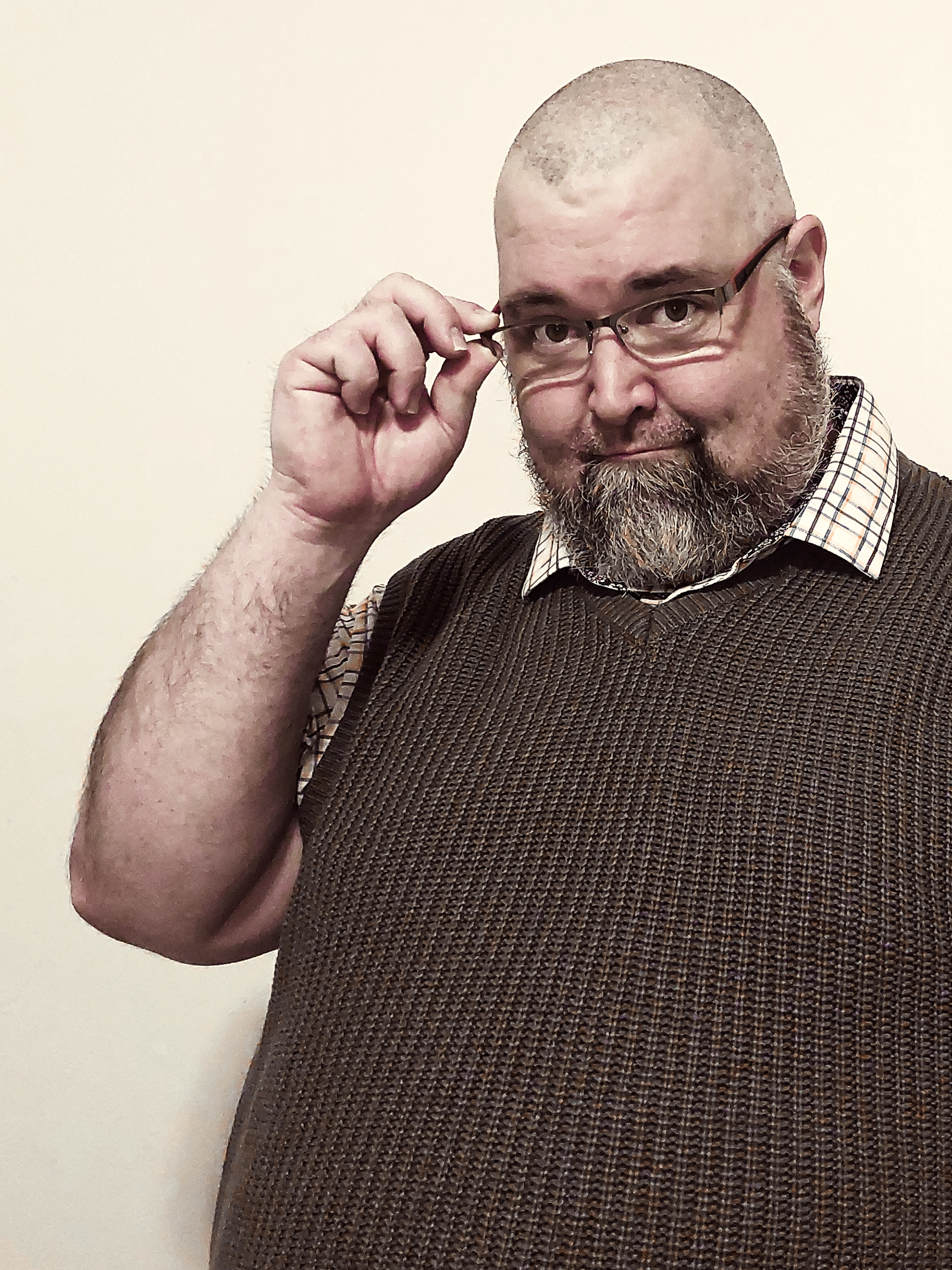 A photo of S. James Curtis holding his glasses.