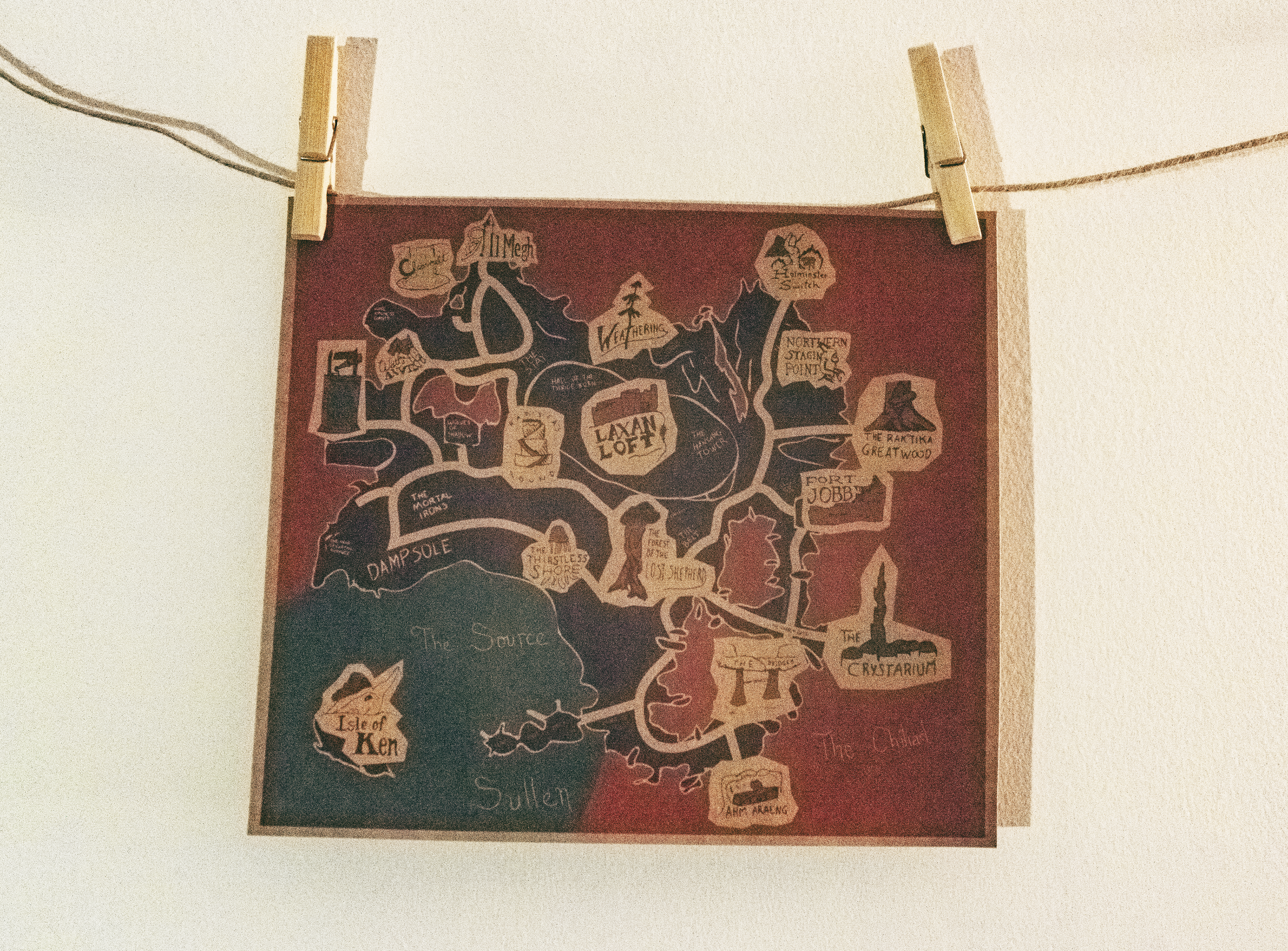 An illustrated map of Lakeland form FFXIV, printed and hung up on clothespins.
