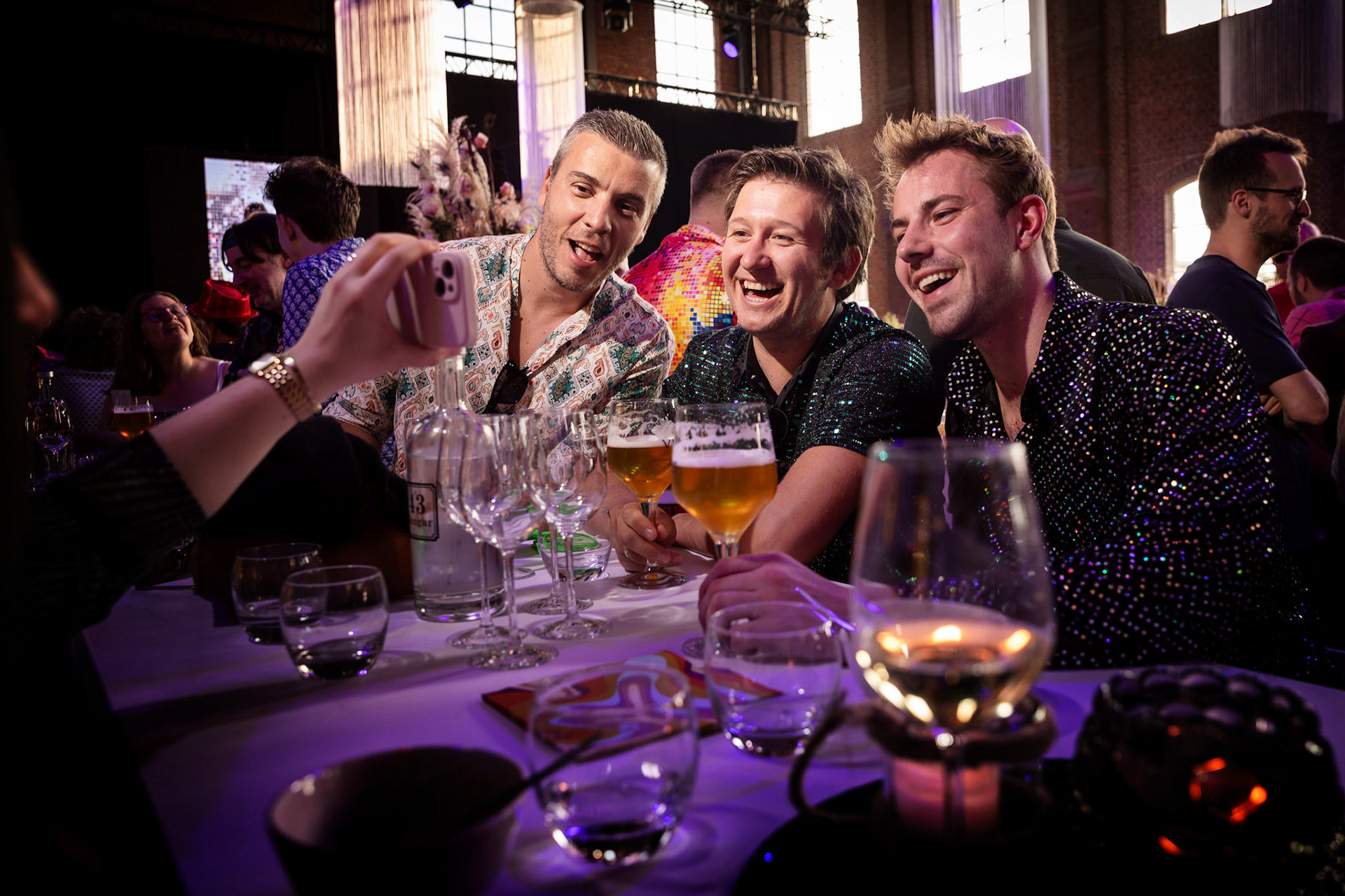 Genietende gasten aan tafel – ontspannen momenten die de essentie van jouw event weergeven.