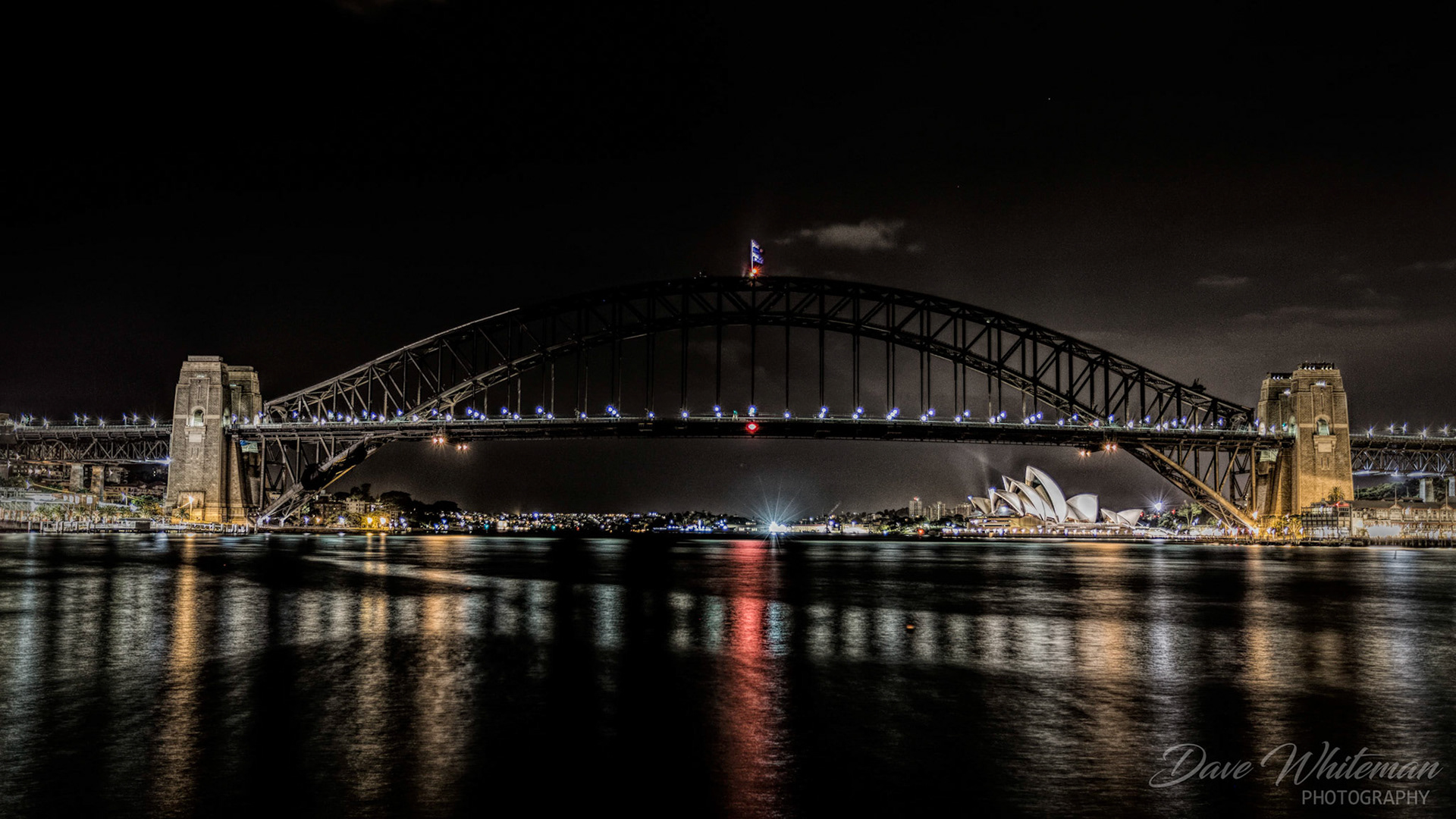 Sydney skyline at night with Harbour Bridge and Opera House.