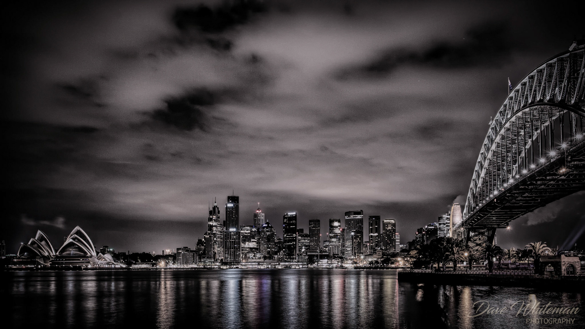 Sydney skyline at night with Harbour Bridge and Opera House.