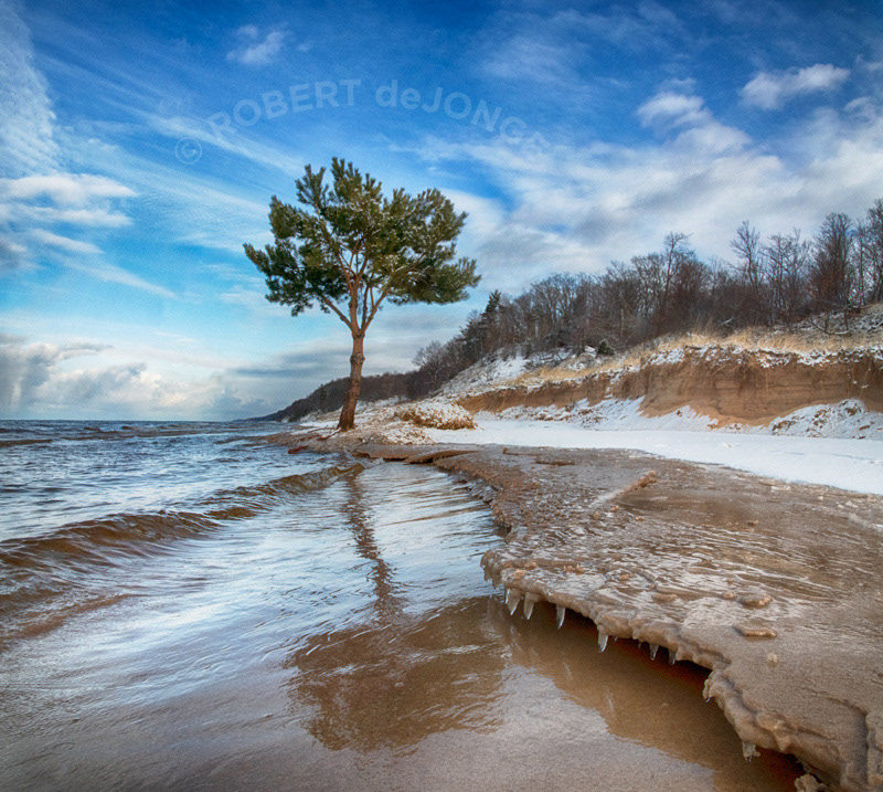 An icy ledge forms along the shore of Lake Michigan, holding back the relentless wave action. Hoffmaster State Park, winter