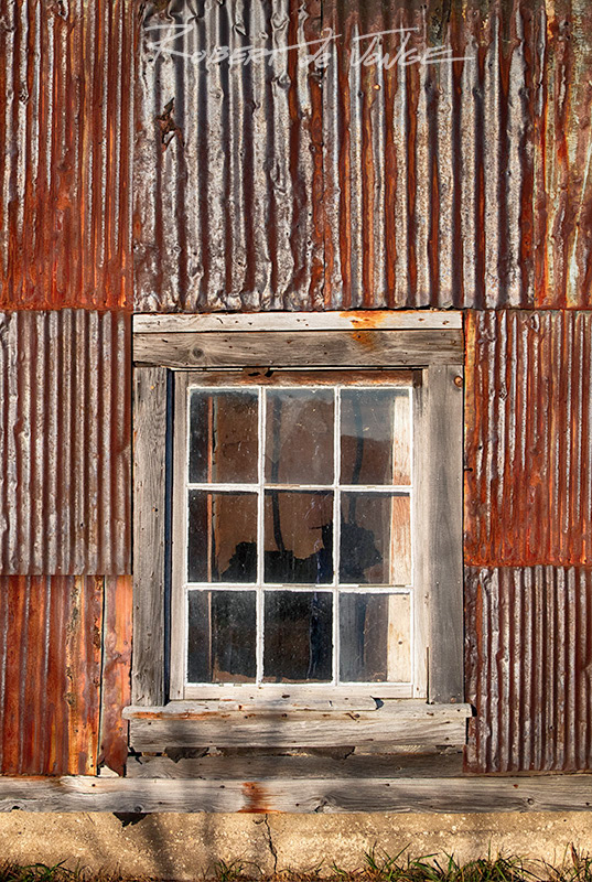 Rusted and patinaed siding and window on a shed in the Port Oneida District