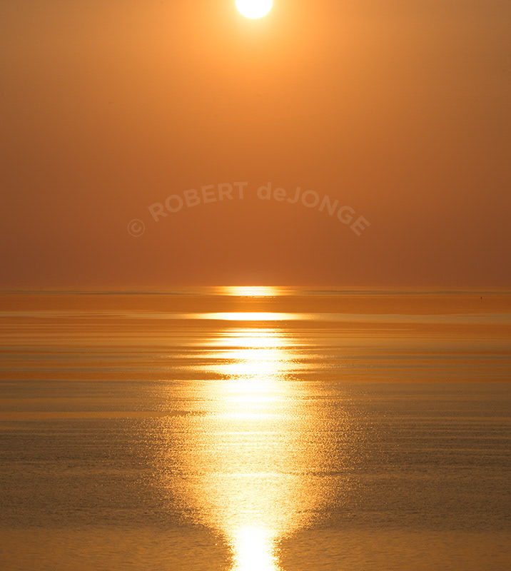 The Sun sets through a haze caused by western wildfires at Sleeping Bear Point, Glen Haven, Michigan