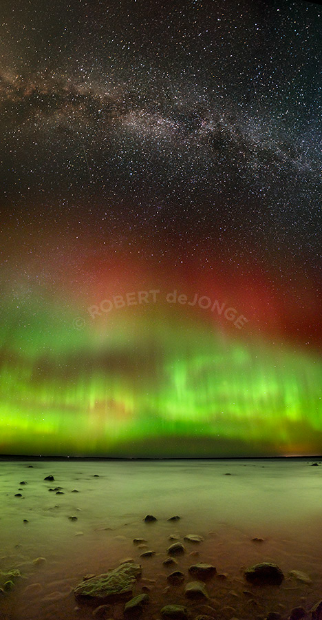 The Aurora Borealis dances over Sturgeon Bay which is part of Wilderness State Park, Michigan