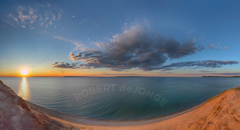 The sun sets over the Manitou Passage as a cloud rises over the Manitou Islands. 180° Panorama