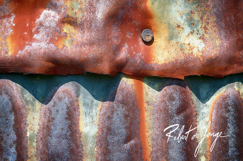 Rustty corrogated siding displays a rhythm of shadows 