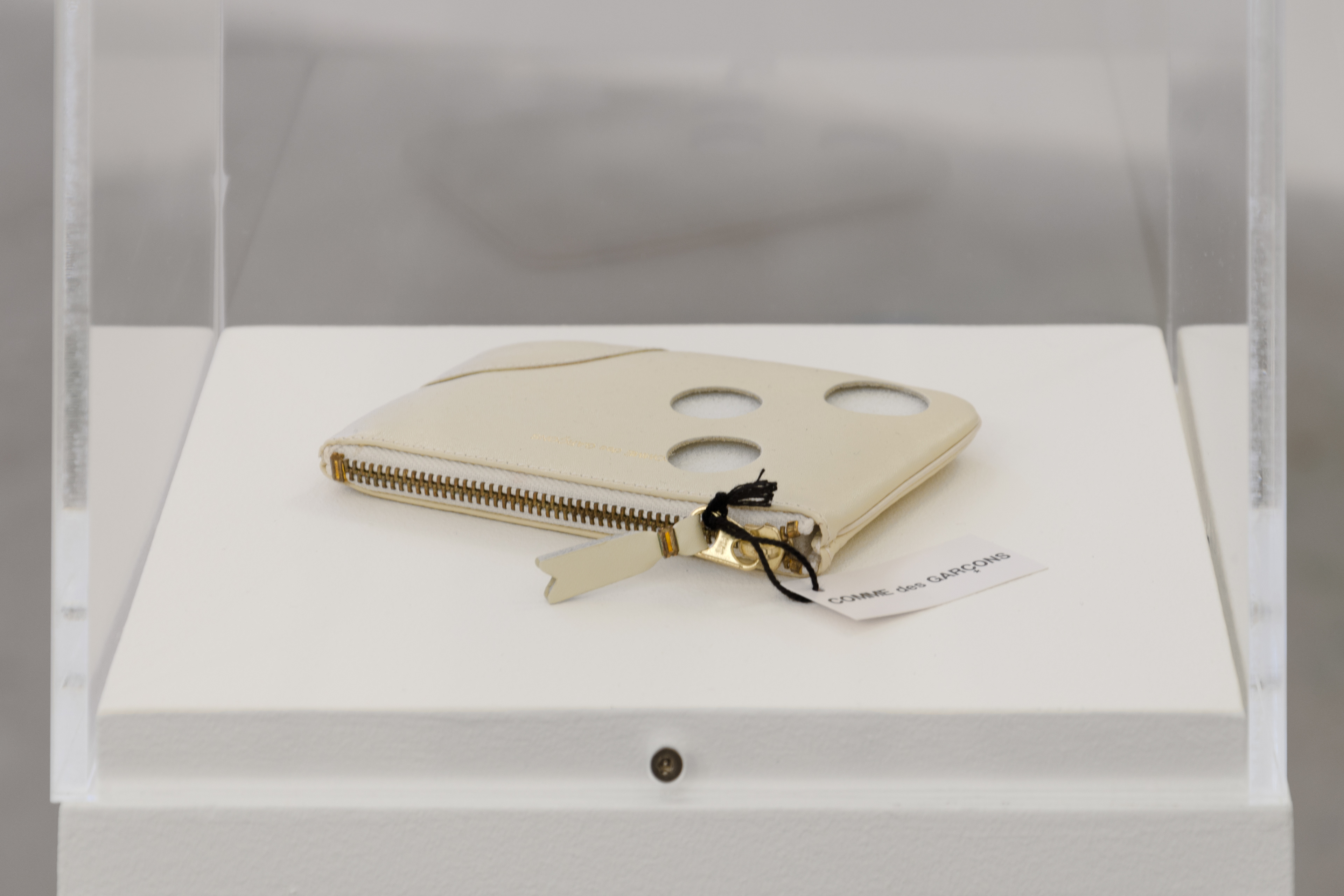 “It came out of nowhere” he said staring at the empty space (Off-White Coin Holder); 2012; An Off-White Coin Holder made by Comme des Garcons that has had holes cut from it in the size of 1 and 2 Euros coins; 14 × 10 × 1.5cm