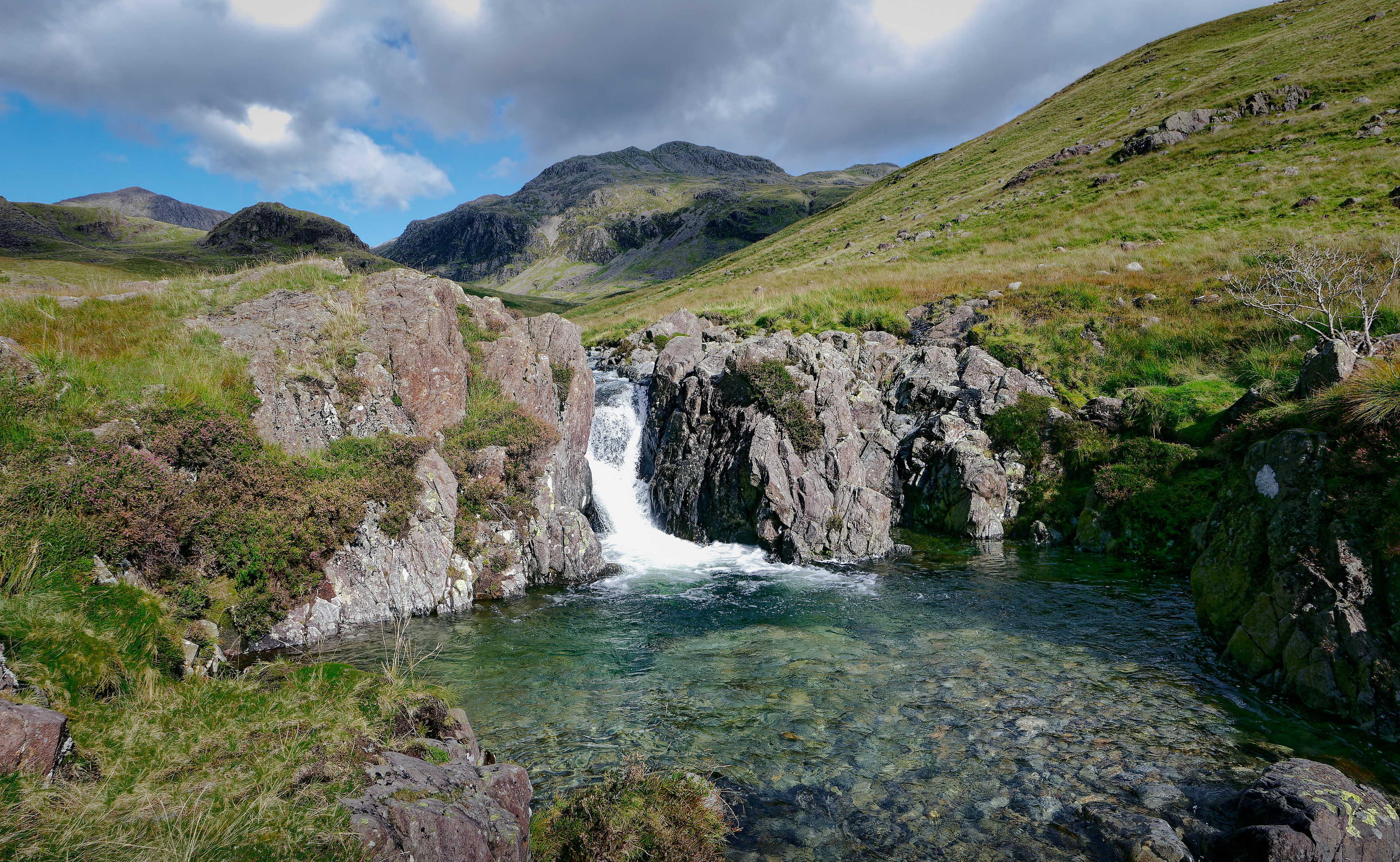 This curatorial selection is driven by an atmosphere of profound geological isolation, capturing the serene yet powerful tension between the enduring strength of the mountains and the restless grace of the water.