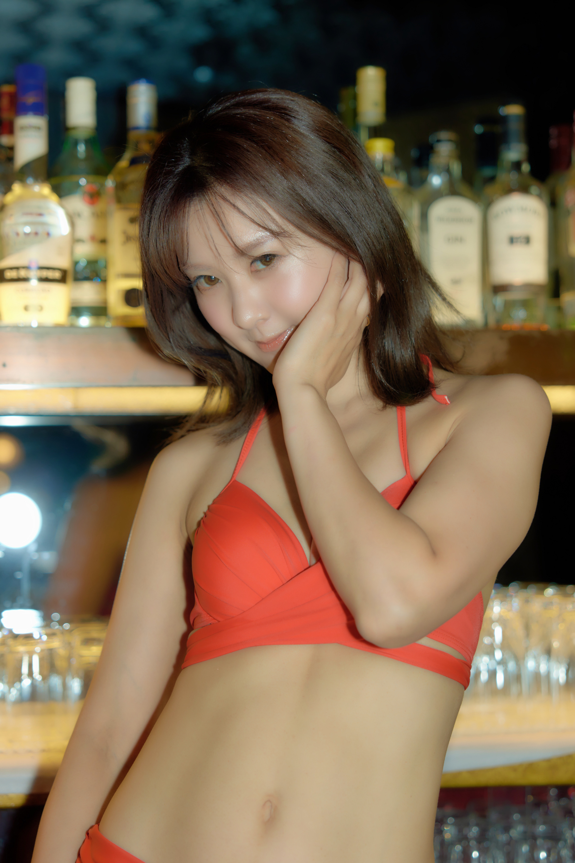 (工夫)ストロボ撮影、露出調整、レタッチ、クラブのカウンタ内の水着の愛久奈さんです。暗い室内でストロボをたいてモデルの肌をきれいに撮りました／(カメラ)CANON EOS R5／(レンズ)CANON RF24-70mm F2.8 L IS USM／(撮影日)2022年7月24日／(撮影場所)クラブシルビー／(モデル)三宝愛久奈