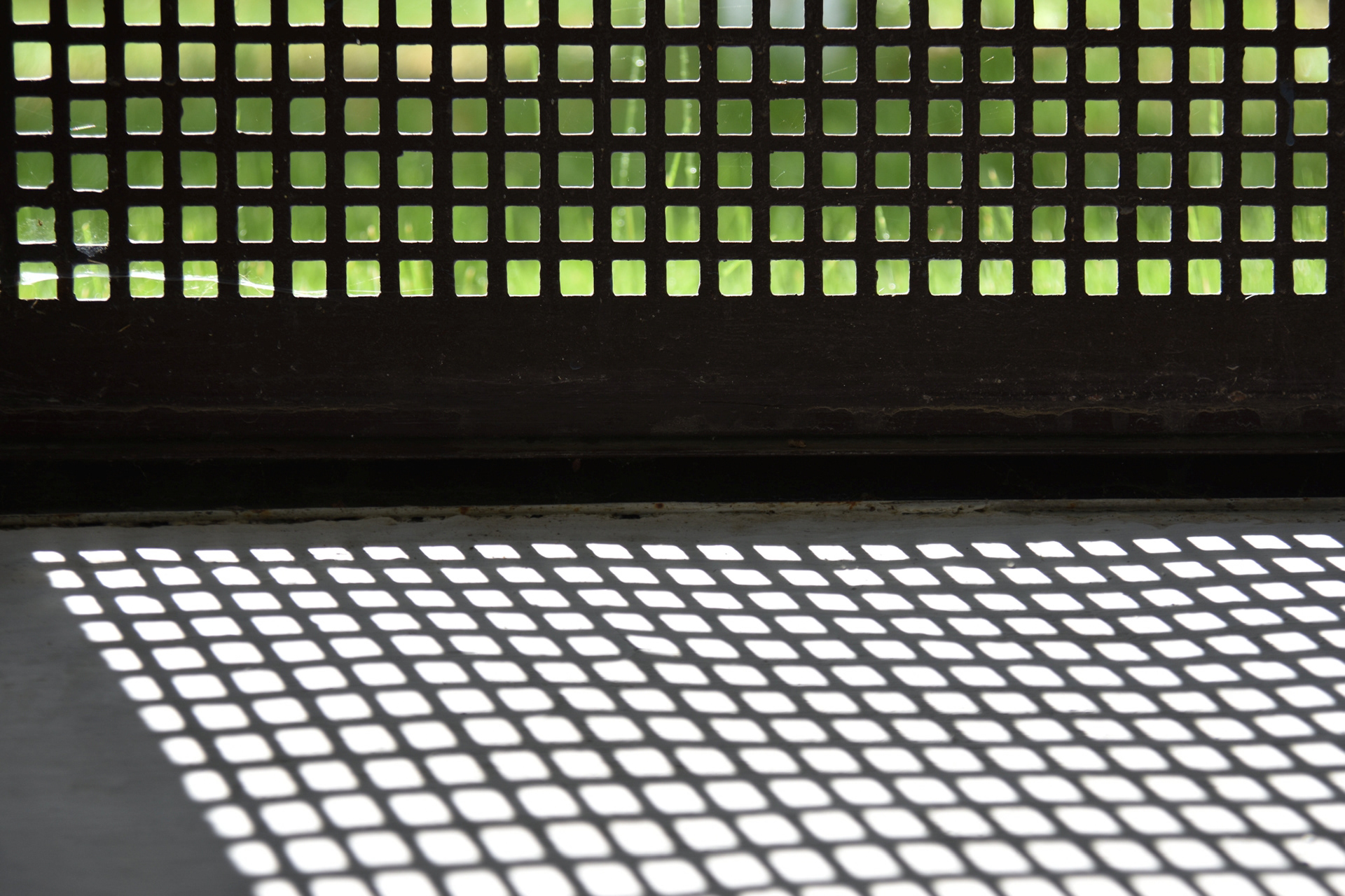 Einer der wenigen sonnigen Momente an dem Vormittag wurde für diese Aufnahme genutzt: Durch das Gitter einfallendes Licht zeichnet ein Muster auf das Mauerwerk