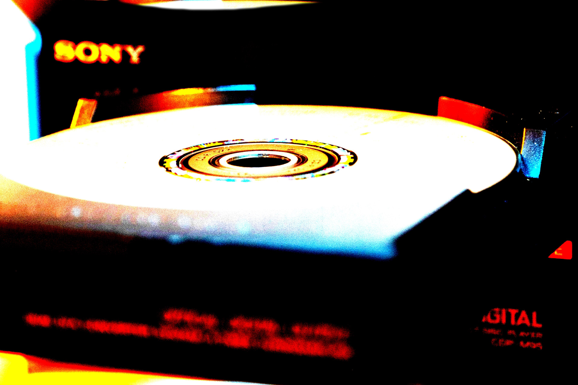Close-Up-Aufnahme der Schublade eines CD-Players, nachbearbeitet mit Mitteln der Farb- und Kontrastverstärkung