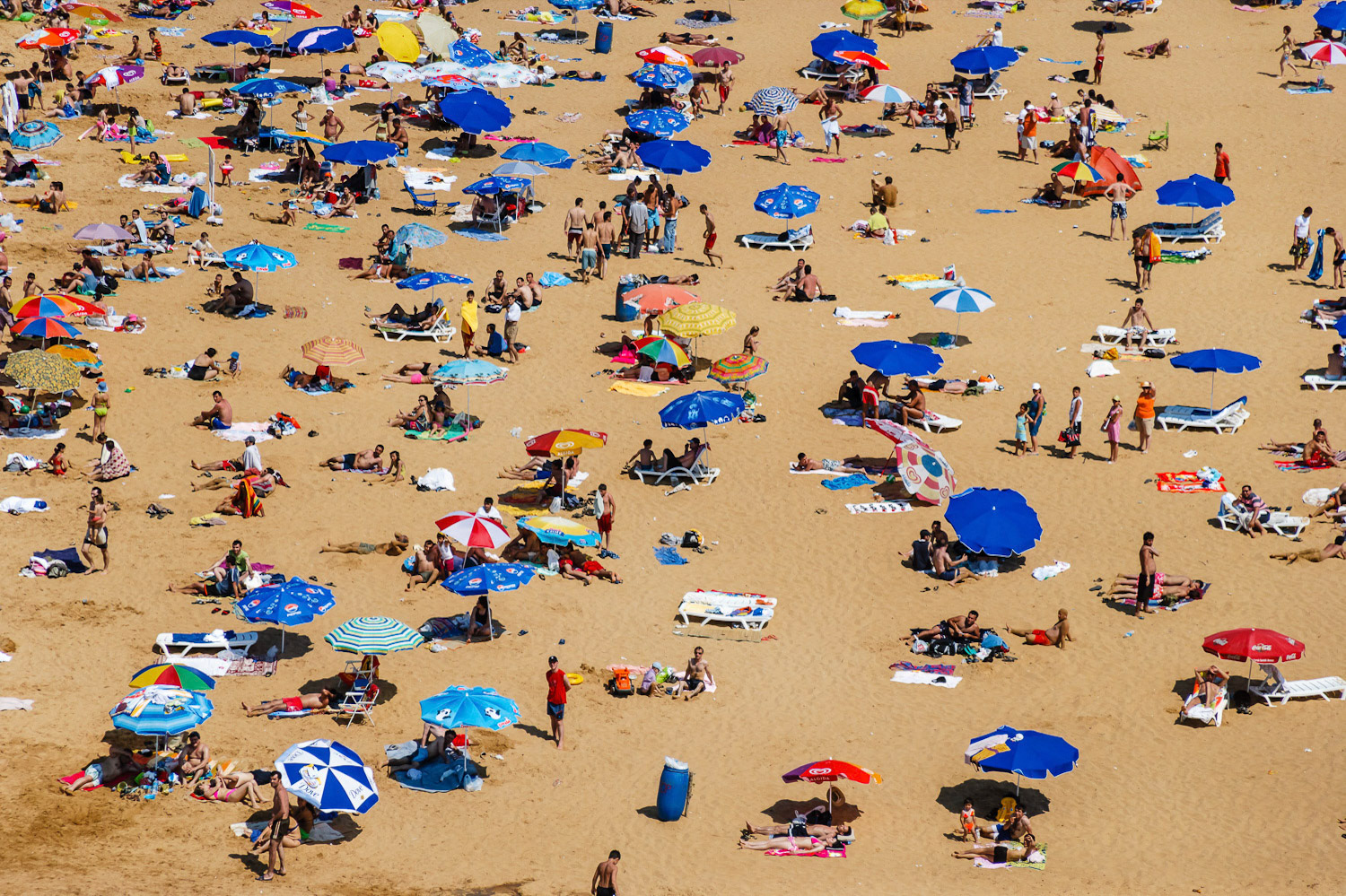 "Beach" - As I was approaching this crowded Black Sea beach I realized from far away that I had never seen it that crowded before. Quickly I aimed my telephoto lens and selected the part where most people were concentrated and captured a wall to wall texture of beachgoers, colored umbrellas, and the sand as the backdrop.