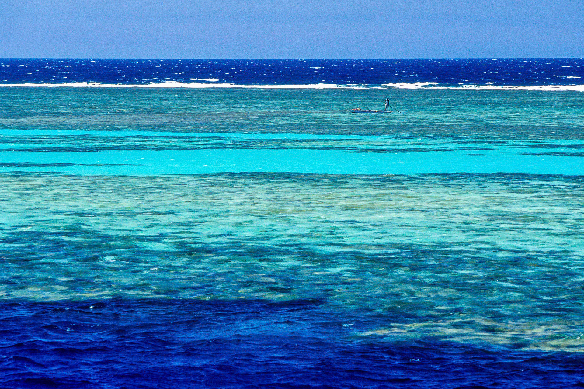 "Panorama Reef" - All tones of blue are present in this photograph that I shot at the Panorama Reef in the Red Sea. Above the water is just as impressive as the underwater. The fisherman on wooden boat complements the horizontal lines and give scale to the image.