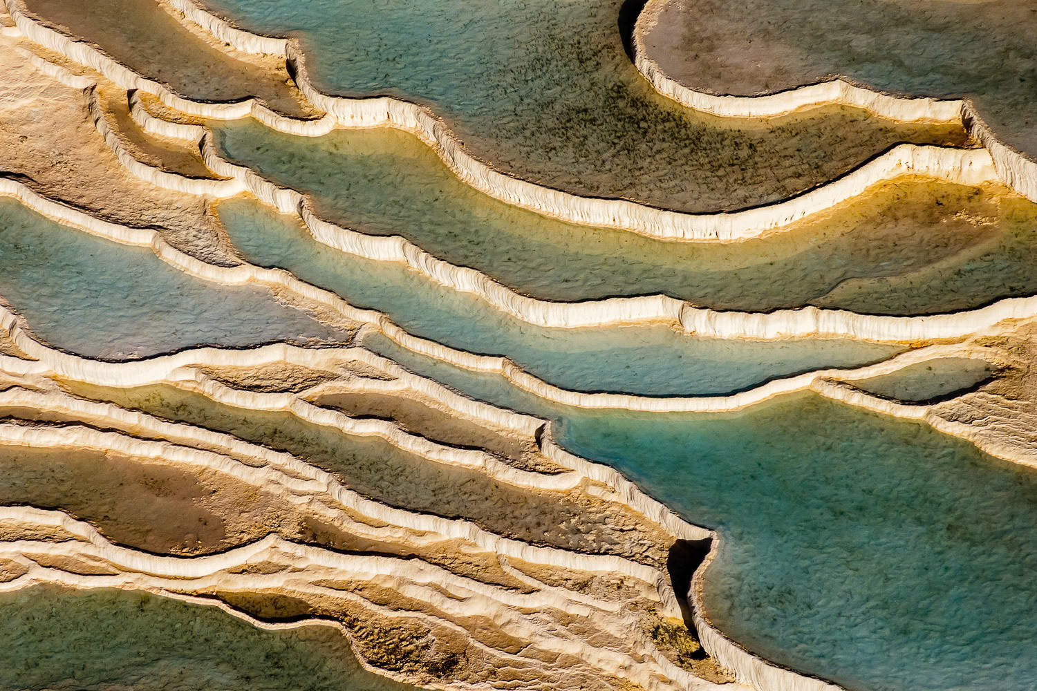 "Pamukkale" - Pamukkale, meaning "cotton castle", is a natural site in Denizli in southwestern Turkey. The area is famous for a carbonate mineral left by the flowing water. The ancient Greco-Roman city of Hierapolis (Holy City) was built on top of the white "castle". I wanted to isolate and capture the graphic lines of naturally formed pools and terraces in this historically significant natural wonder from the air.
