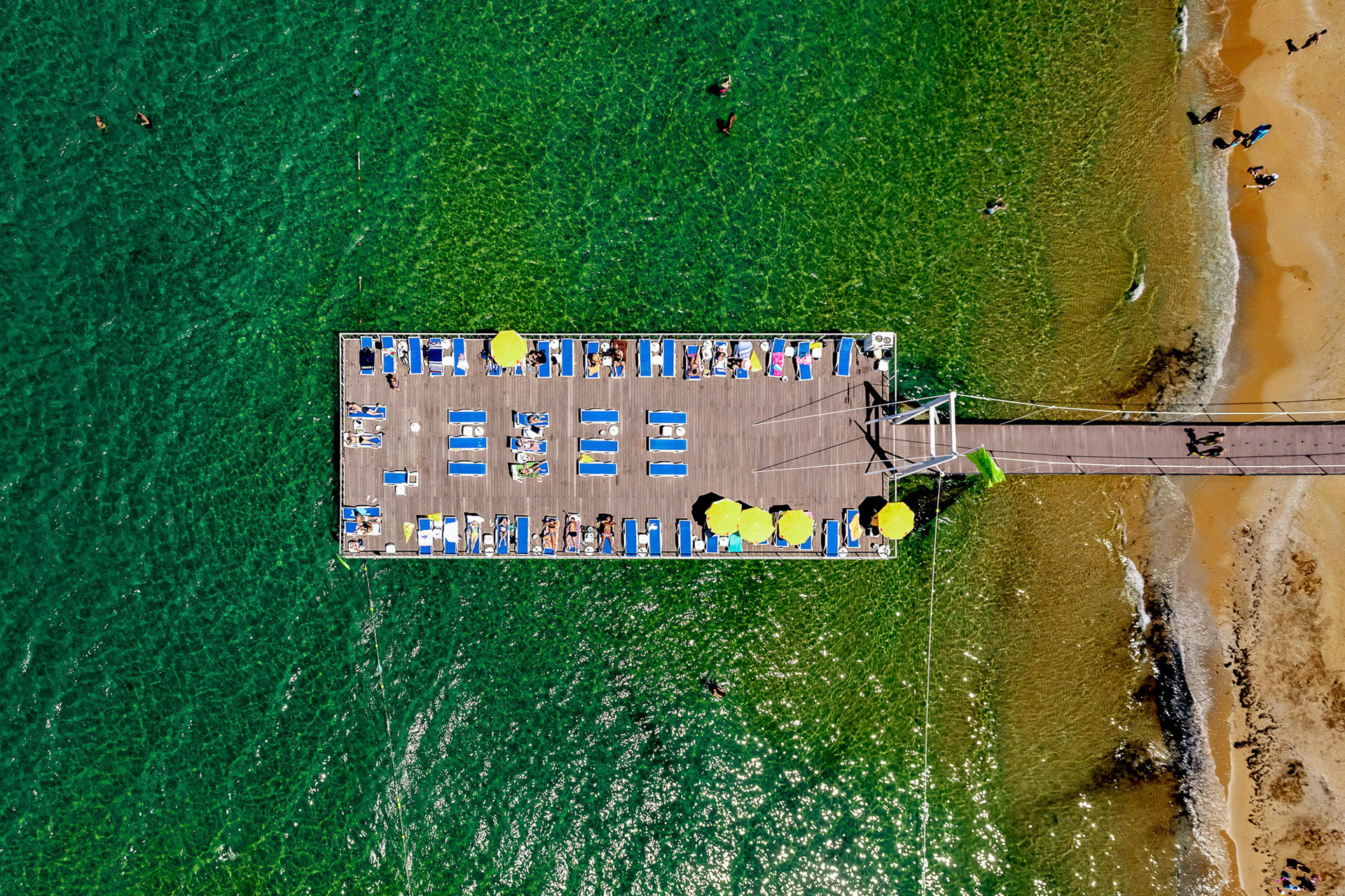 "Sun is Shining" - I shot this photograph image while flying with my paramotor over beachgoers basking in the sun on and around a platform resting above the blue-green waters of the Black Sea in Istanbul.