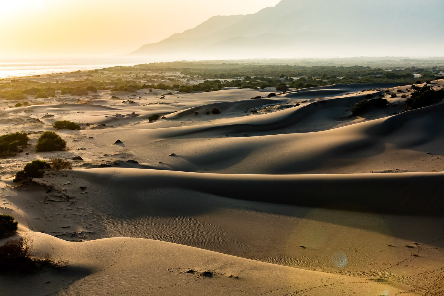 "Dunes of Patara" - While flying with my paramotor in preparation of a new series I took this aerial photo of the sand dunes in Patara Beach. It is one of the most beautiful beaches on the Mediterranean Sea. It’s 18 kilometres long, the longest in its region. The beach is near the ancient Lycian city of Patara which is the birthplace of St. Nicholas (Santa Claus). I was returning to my landing spot and saw the sand dunes backlit by the typical soft pinkish yellow Mediterranean summer sunset light. When I landed I realized that I had maybe a minute worth of fuel left!
