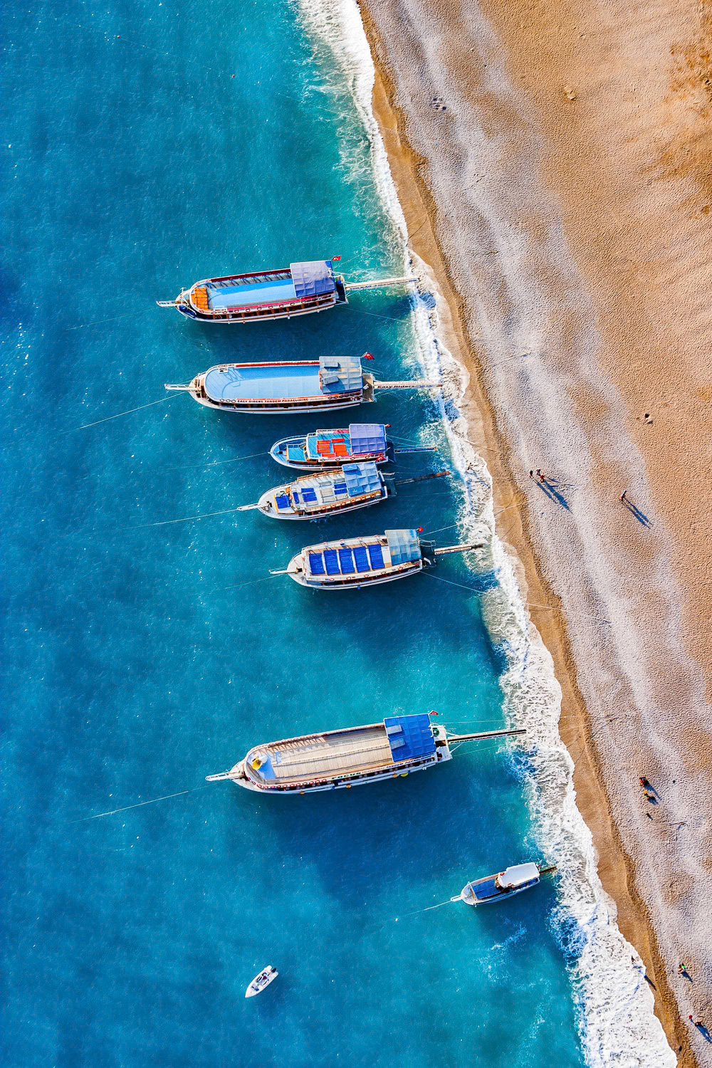"Oludeniz Boats" - It was my second year of flying a paramotor. I was still considered a novice. I traveled to Oludeniz, on the Mediterranean coast of Turkey, a heaven and one of the most popular spots in the world for paragliding. I found a narrow strip on the sidewalk next to the beach and took off. Being careful not to collide with hundreds of paragliders going for their landing on the beach I flew along the coastline and grabbed this shot.
