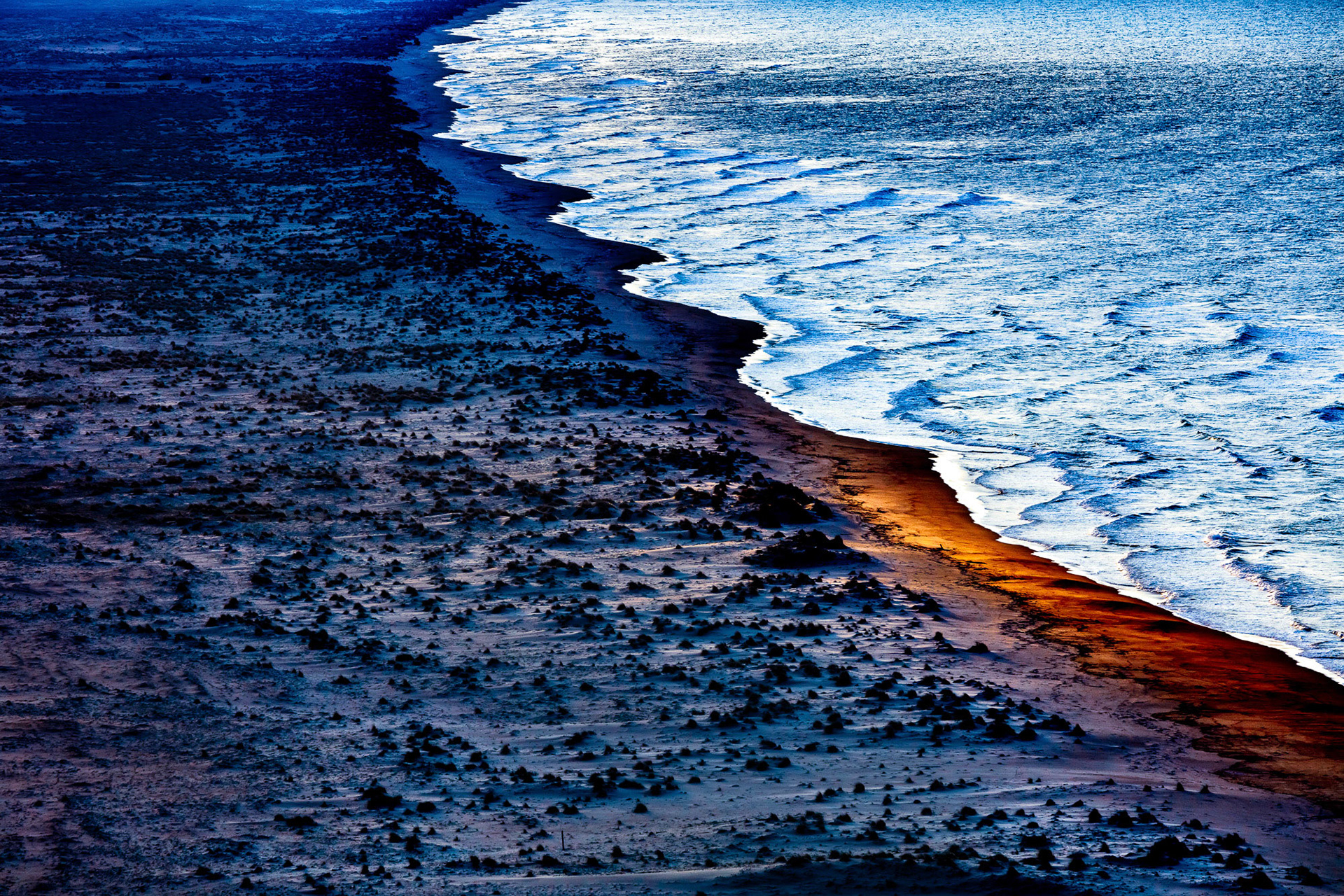 "A Light in the Dark" - This very long and wide rough Black Sea sandy coast with wild plants growing all over it was a perfect candidate for the Untamed series. As I was photographing it on a dusk flight, suddenly a hole appeared in the cloud cover and the coppery golden sunlight shone briefly on a small part of the beach. Luck is what happens when preparation meets opportunity.