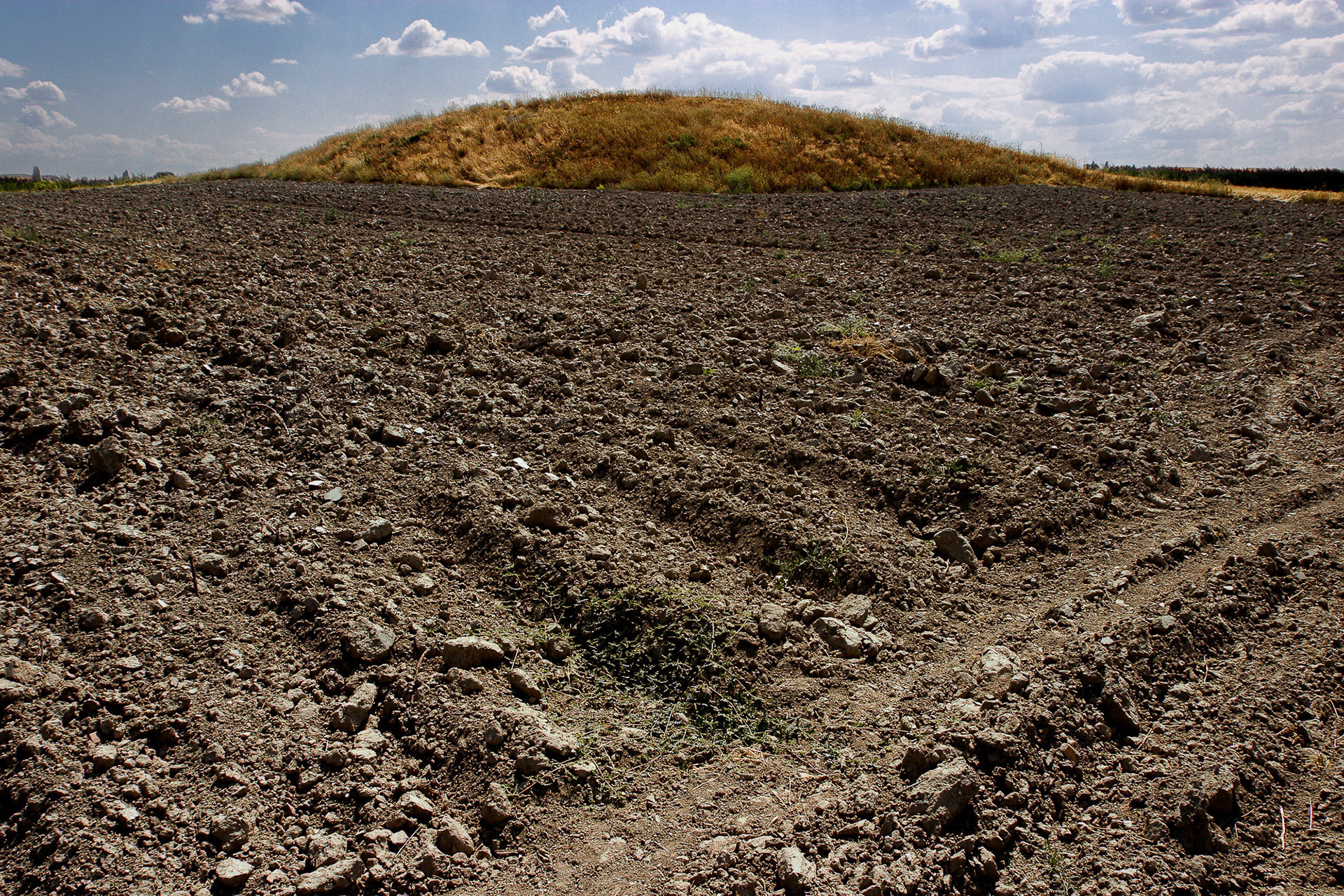 "Kesilmis" - The name of this mound literally means "Cut". The plowed fields around it cut into the mound and destroy artifacts. One can always find pieces of ancient pottery on cultivated land around mounds, a telltale sign that the mound is indeed a historical settlement mound.