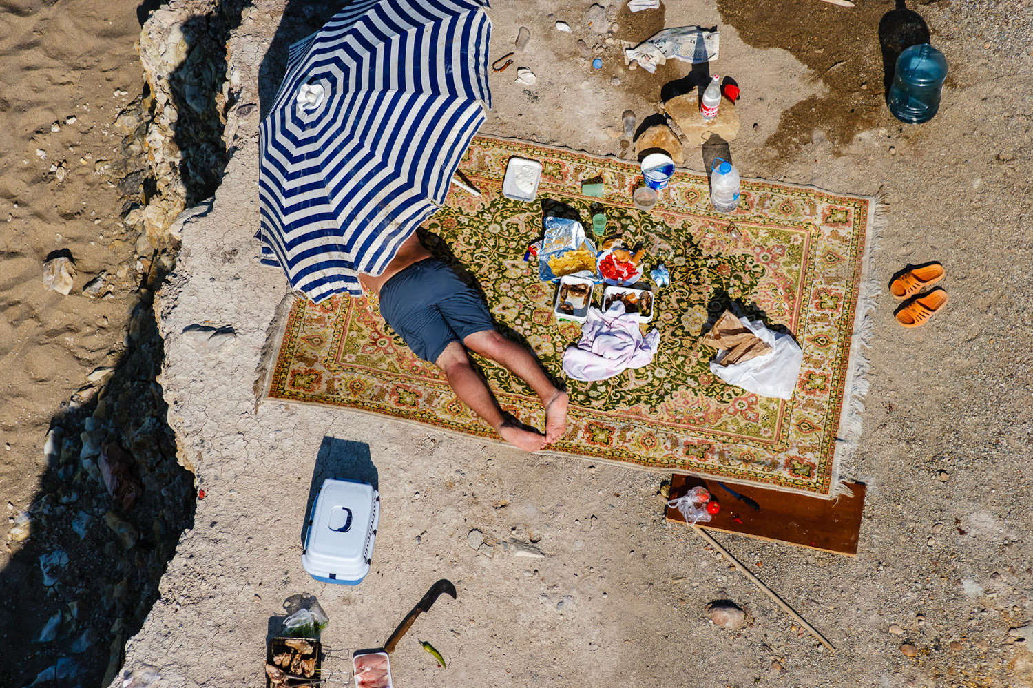 "Picnic" - When I saw this man on a ridge at the Black Sea coast I made a low pass above him and took just one shot. The photograph has all the ingredients of a local guy at a seaside picnic. I show this image at my seminars when explaining about information theory in photographic composition. When a local person sees the familiar details in the photograph he or she will know where it was taken, but the content will be unfamiliar and new to others. See if you can tell where it was shot.