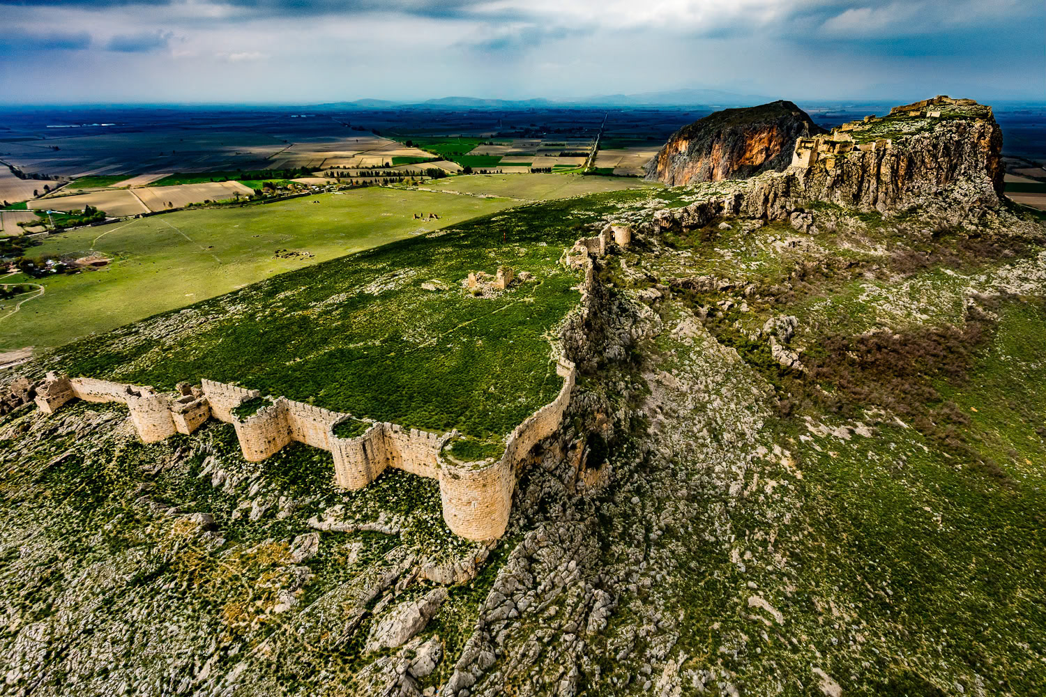 "Anavarza" - The ancient city of Anavarza (Anazarbus/Caesarea ad Anabarsum) is located 28 kilometers south of the Kozan town of Adana. Among the important remnants of Anavarza is the medieval castle on the hill rising like an island in the middle of the plain. The magnificent castle and city, reminiscent of a film decor, continues to live in today's village houses with tired stones bearing traces of the past. My paramotor broke down after finding a suitable place for takeoff. Fortunately, I had my second motor and I was able to shoot this wonderful castle.
