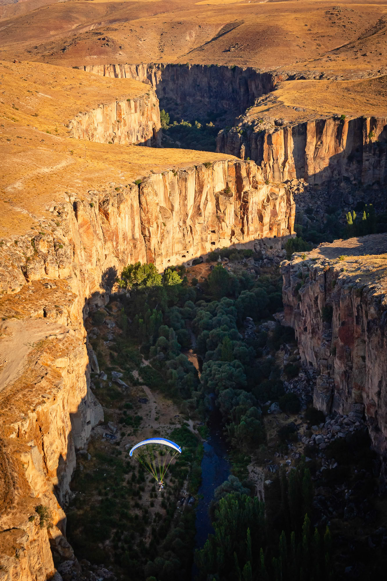 "Ihlara" - A paramotor in the air is dwarfed by the 15 km long Ihlara valley with its 50 rock-hewn churches and numerous rock-cut buildings in Cappadocia. The bottom of the gorge is covered with trees and rocks alongside a river. There is no place to land in case of an engine failure. Sometimes we take risks to grab striking images.