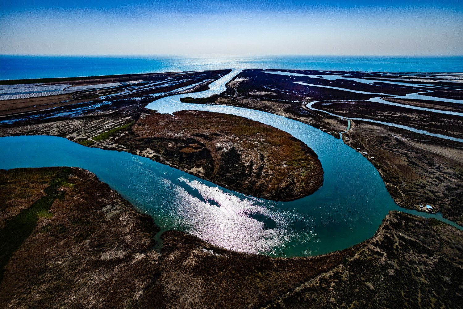 "Seyhan" - Seyhan River is the most important of Turkey's rivers flowing into the Mediterranean. Its length is 850 kilometers. I wanted to capture the exquisite curves of the Seyhan River. I figured that I could do this in the delta where the river flows into the Mediterranean and it would be easier to reach the region from the air. So I decided to take off from Akyatan Lake, 25 kilometers east. I reached the area after a long flight. When I flew behind the big curve of the river to capture the photograph that I wanted, I was surprised by the very rough turbulence. The situation was a little dangerous but I was determined. After getting the result that I wanted, I returned to my starting point, again after a long flight.