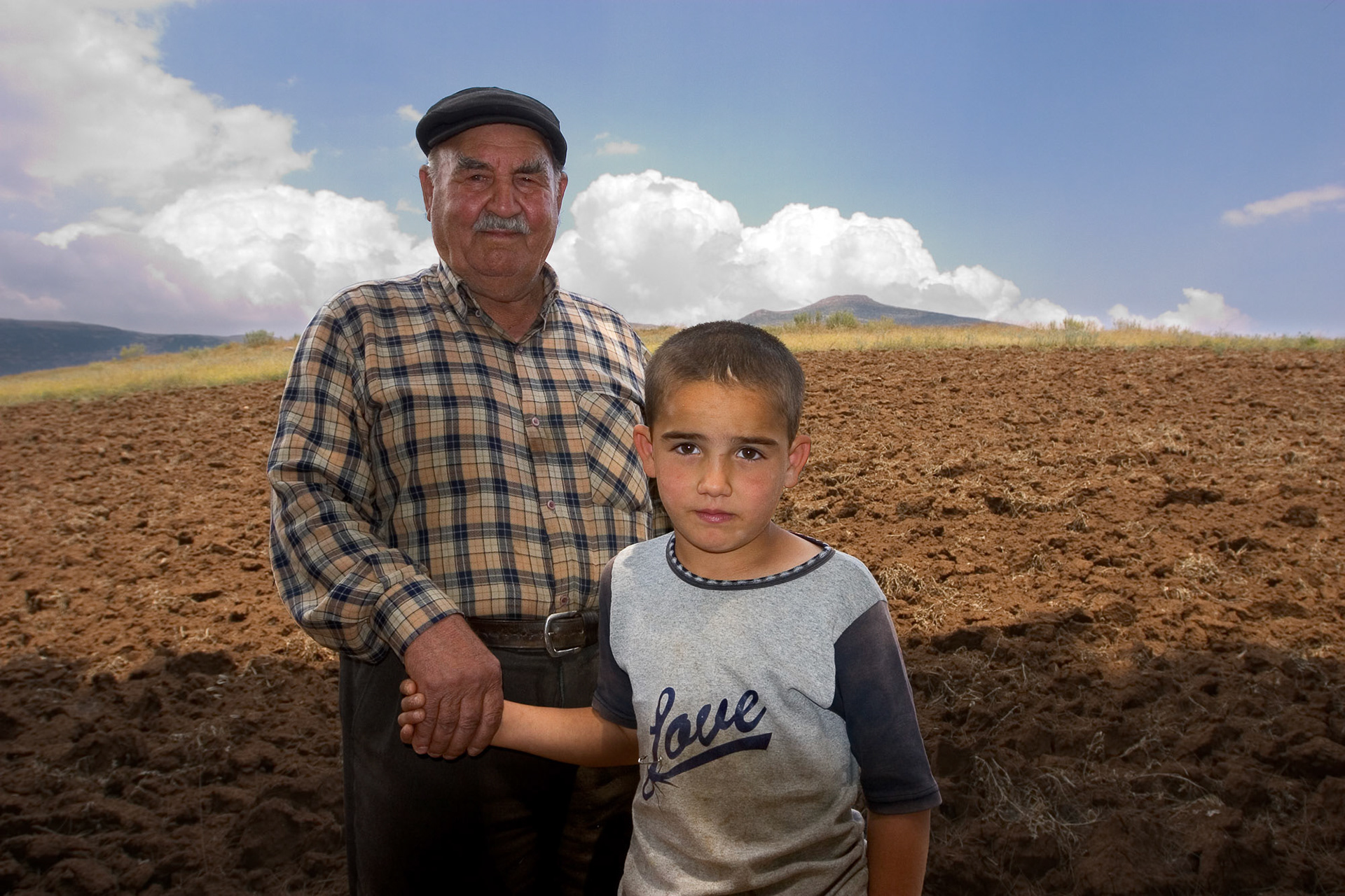 "Tugayli (II)" - I was shooting the Tugayli mound and came across a local farmer and his grandson standing on the mound. I asked if I could photograph them and they posed for me. I am not sure if the grandson knew the meaning of the English word written on his t-shirt but it said it all.