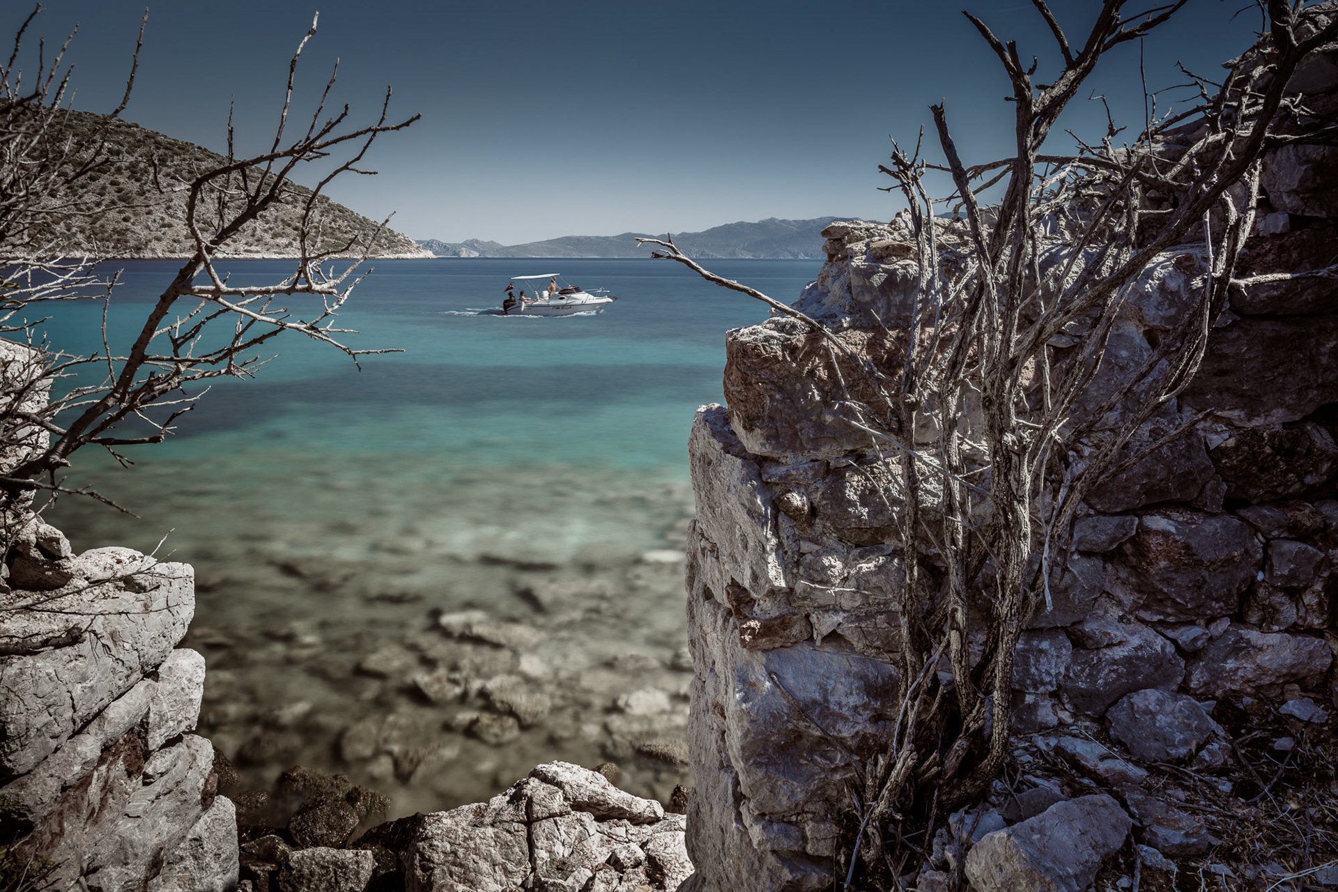 "Ciao Bella" - The lively Mediterranean sea and boat life contrast with the dead plants and ancient ruins in this time exposure image.