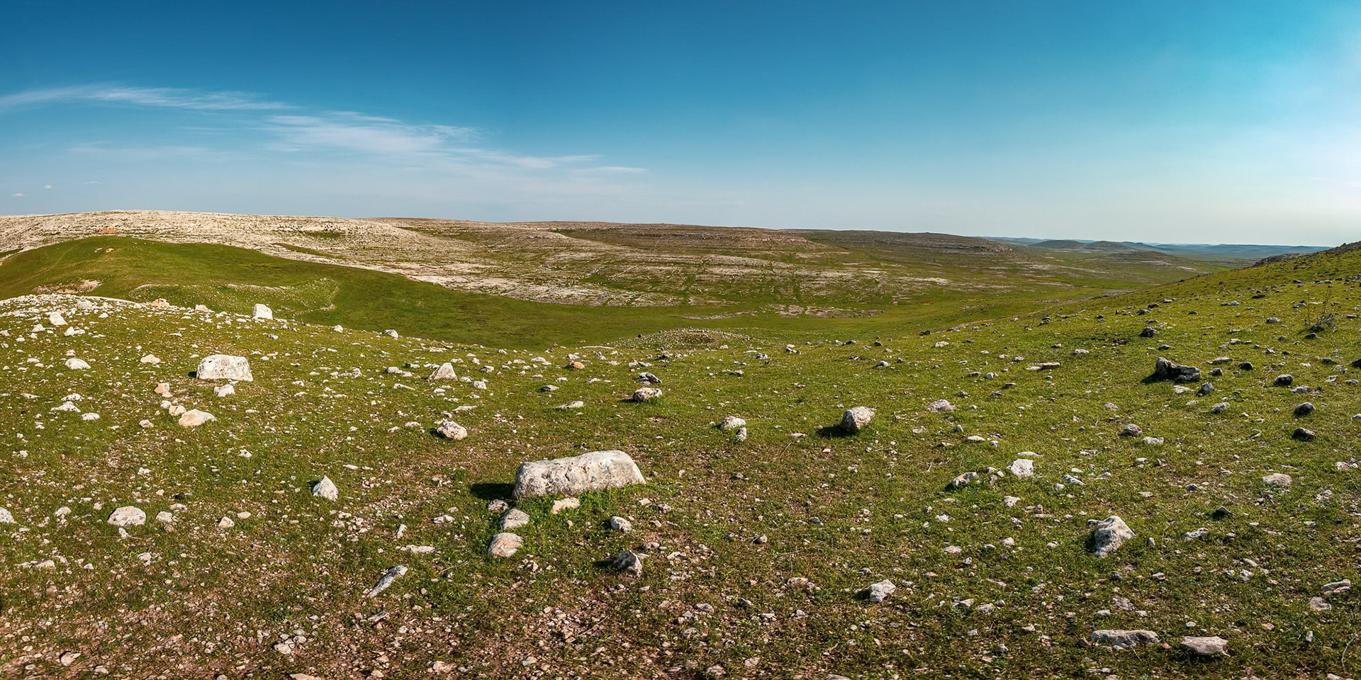 “Karahantepe” - Panoramic view from the peak of Karahantepe which is a Neolithic archaeological site in Şanlıurfa Province in Turkey. The site is close to Göbeklitepe. Archaeologists have also uncovered T-shaped stelae there and believe that the sites are related. The site may be the earliest known human village, predating the construction of Göbeklitepe, dating to between 9,000-11,000 BCE. The large stones seen in the photograph are some of the tips of hundreds of pillars buried in the ground waiting to be unearthed. I imagine the vast uninhabited landscape is similar to what the hunter-gatherers of 13,000 years ago must have experienced.