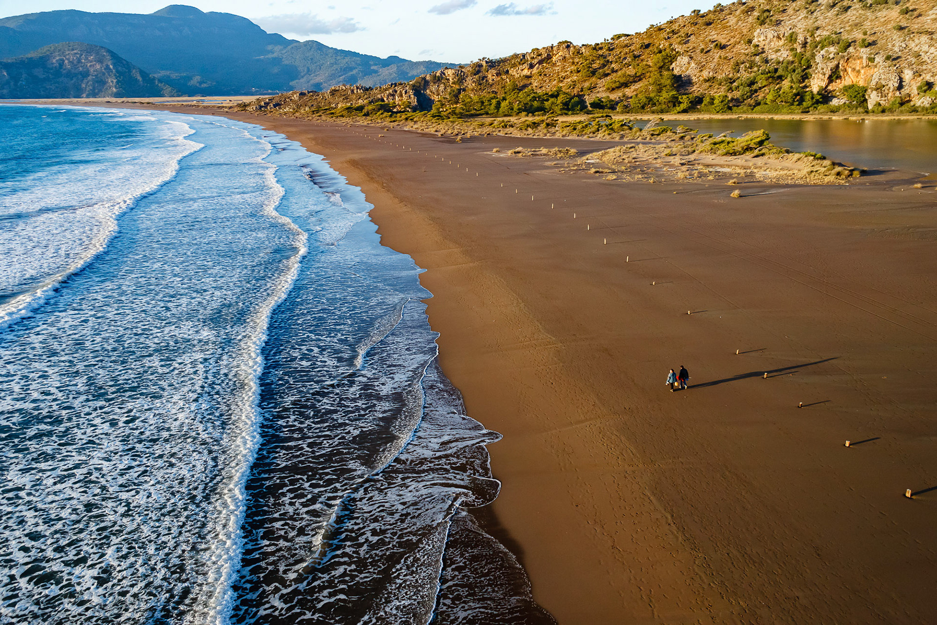 "Iztuzu" - Iztuzu beach is famous as a nesting place for loggerhead sea turtles (Caretta caretta). It is a nature protection area. The couple walking on the sand gives a hint on the size of the coastline.