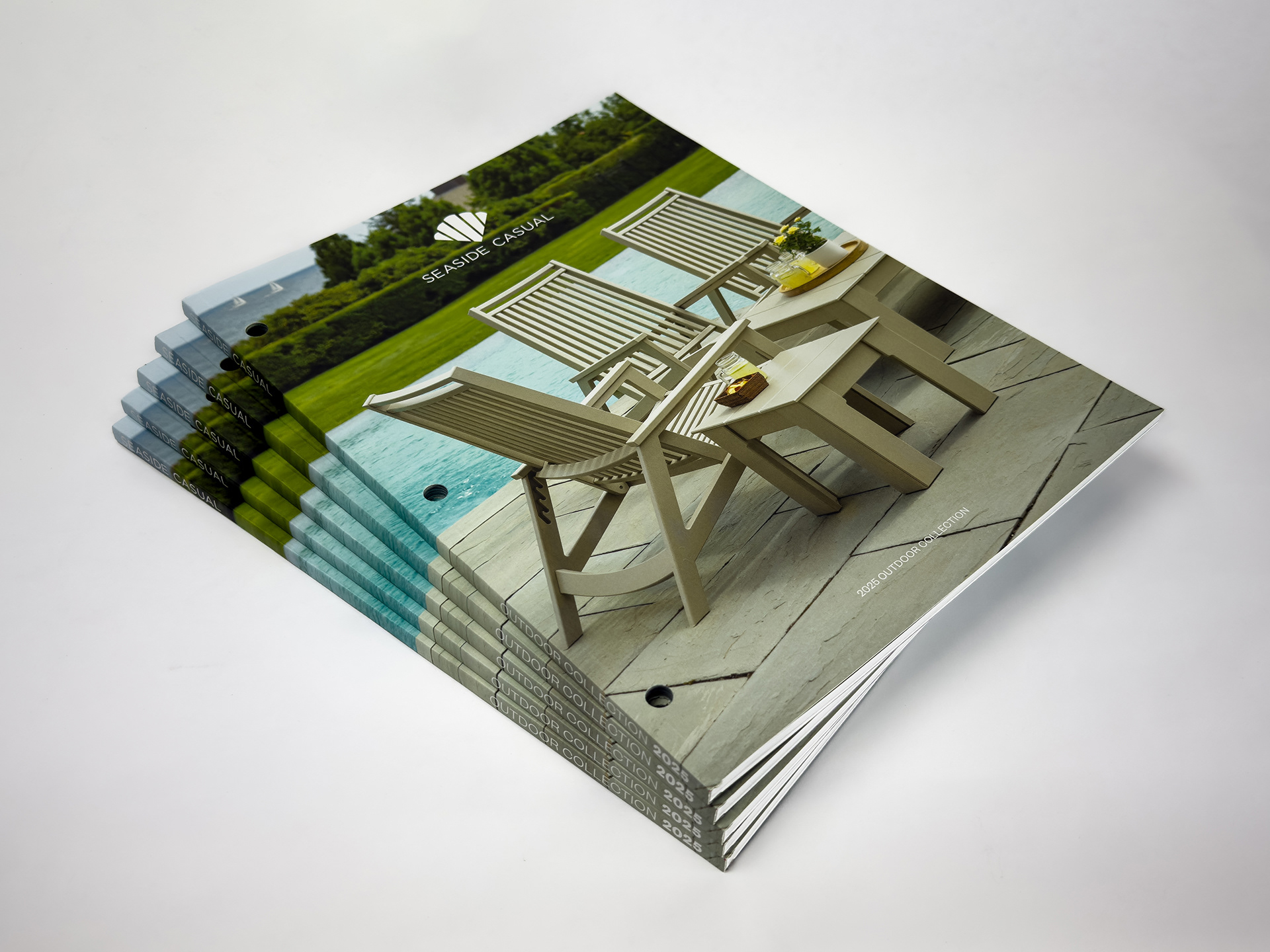 Stack of Seaside Casual 2025 Outdoor Collection catalogs on white background.