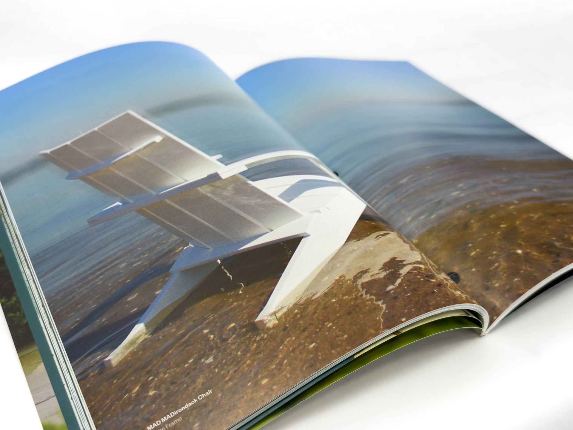 Adirondack chair partially in water with soft horizon background.